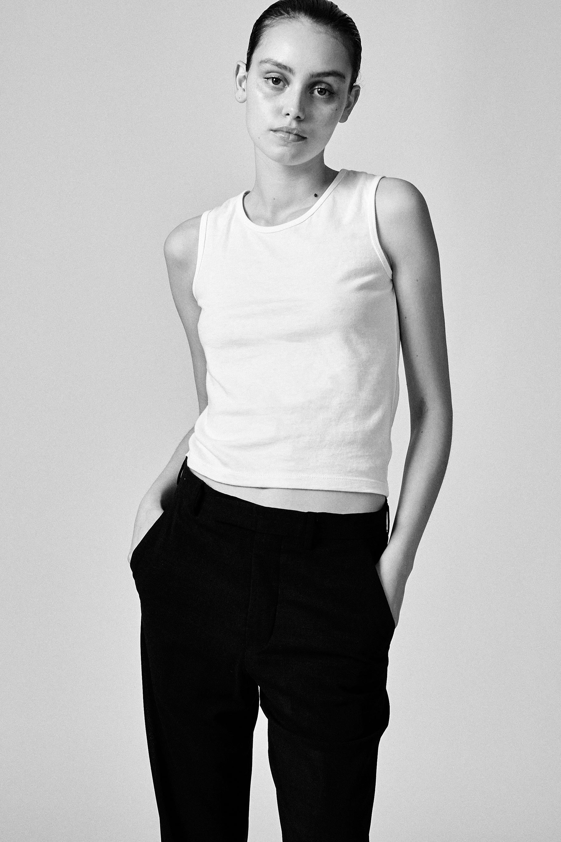 A model wearing the white 03 tank in a white background. 100% made from organic grown cotton.