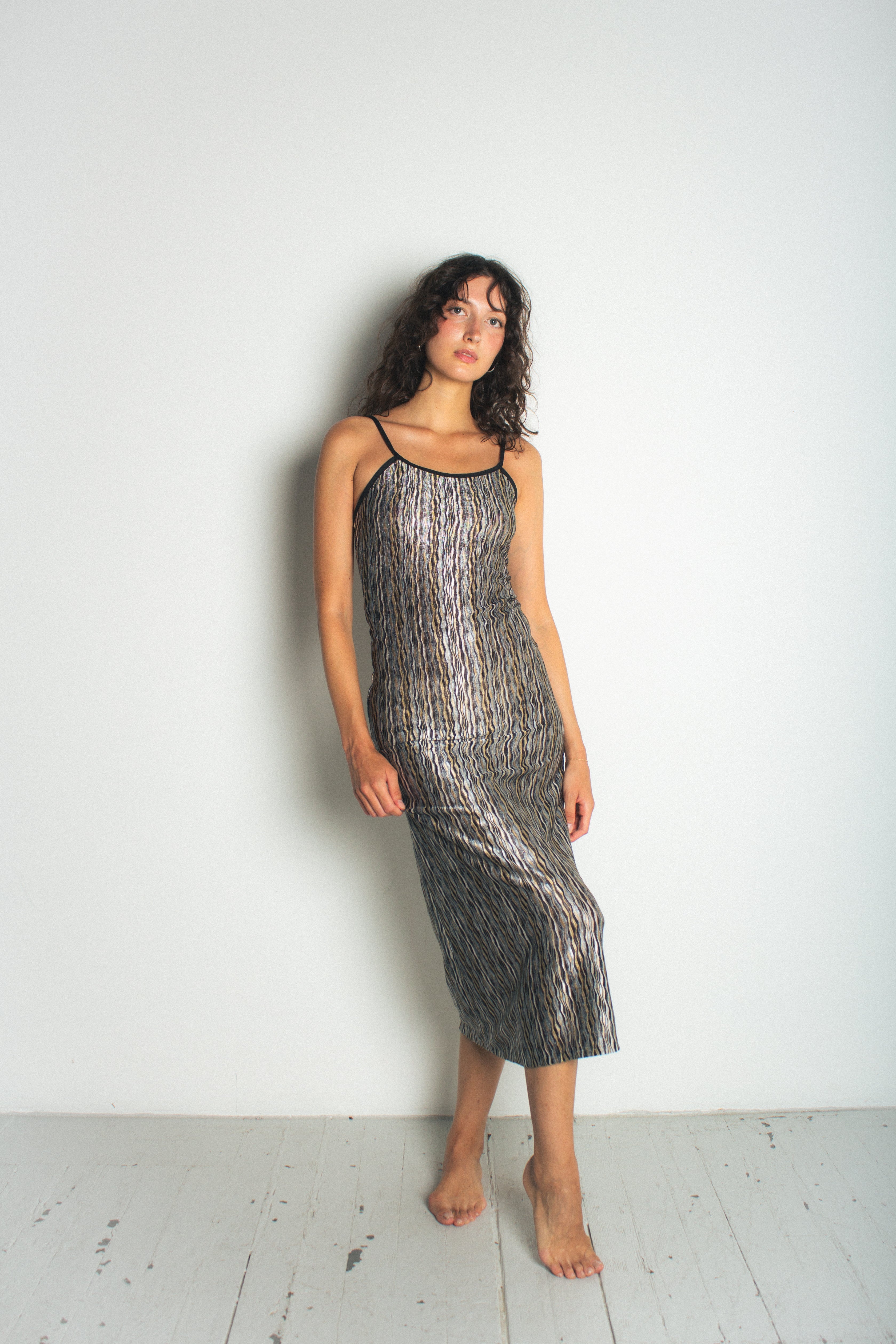 A model wearing the black naomi dress in a white background. 100% deadstock missoni-like, polyester knit blend.