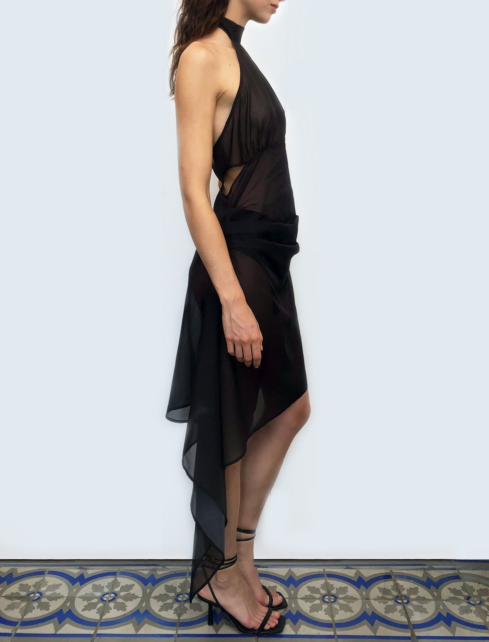 Model wearing a sustainable deadstock black dress against a white background.
