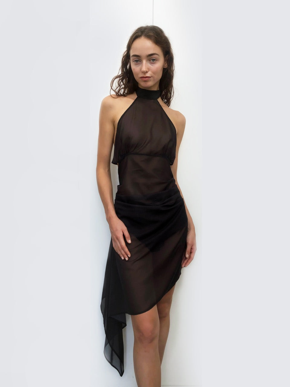 Model wearing a sustainable deadstock black dress against a white background