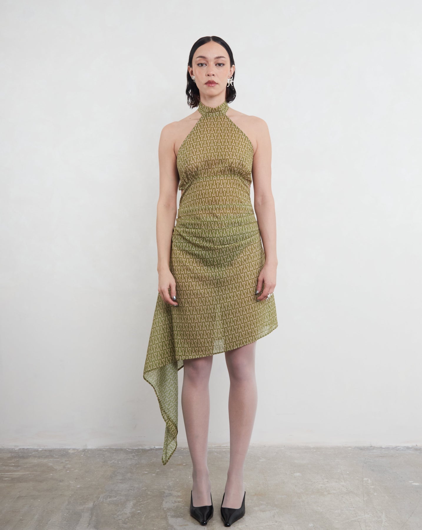 Model wearing a green patterned deadstock dress against a white background