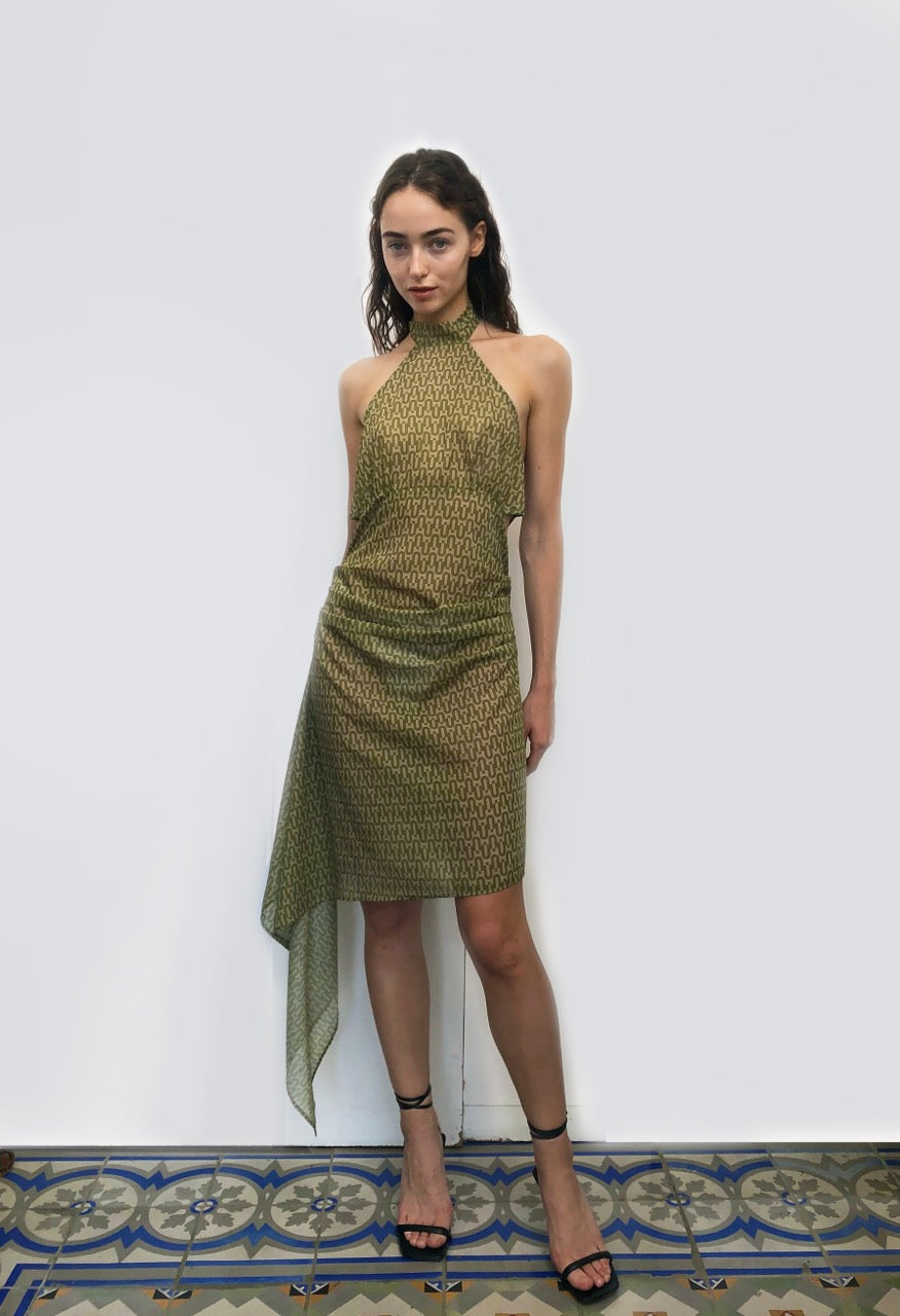 Woman wearing a green patterned sustainable deadstock dress against a white background