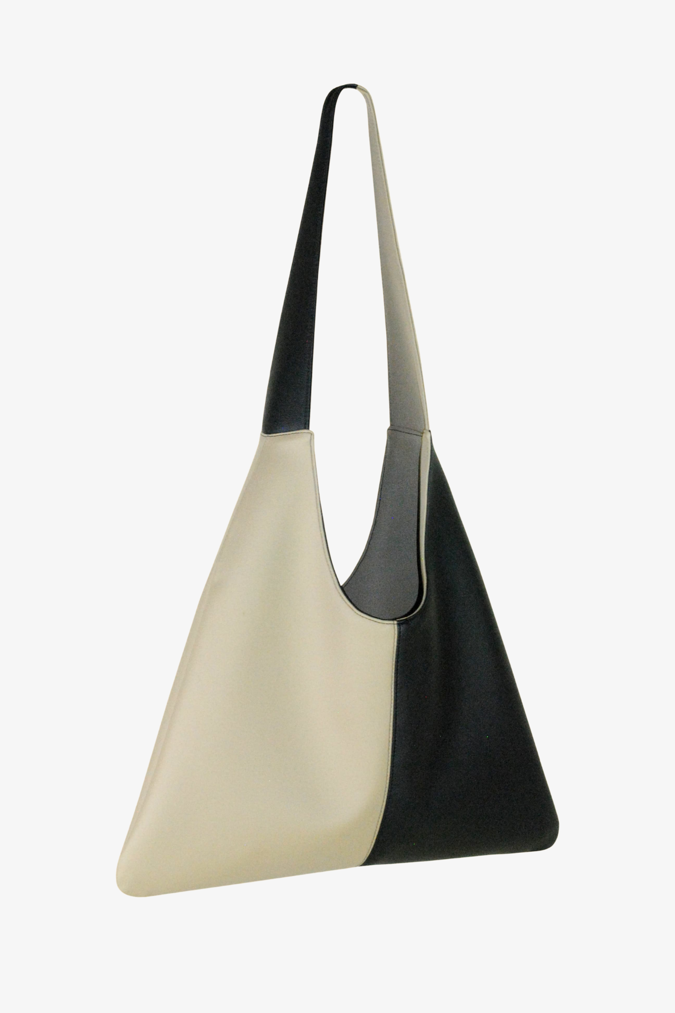 Two-toned black and beige handbag on a white background. Side View. Made from cactus leather and 100% organic cotton lining.