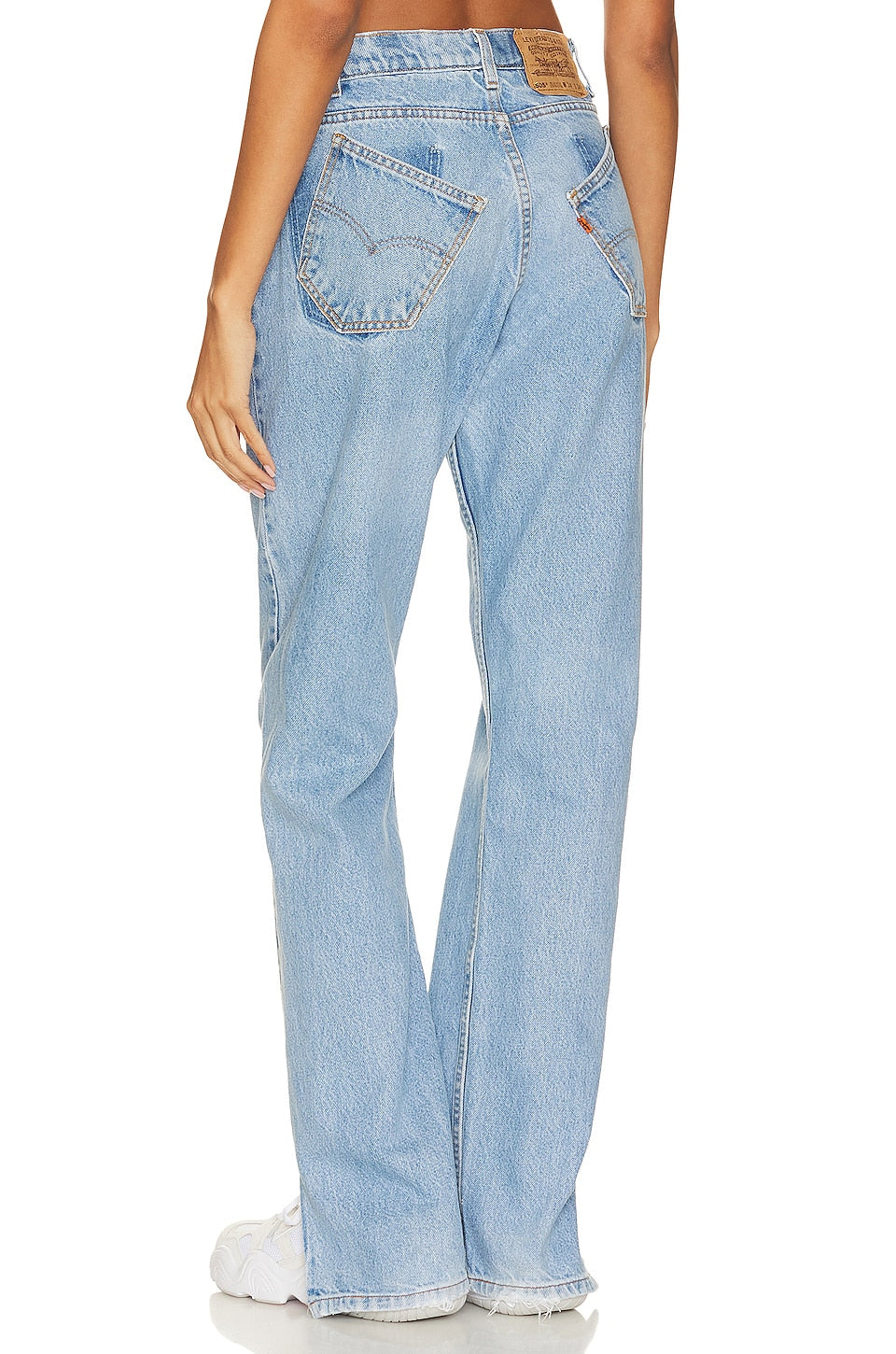 Model wearing a tilted split customs in a white background. 100% made from repurposed Levi’s.