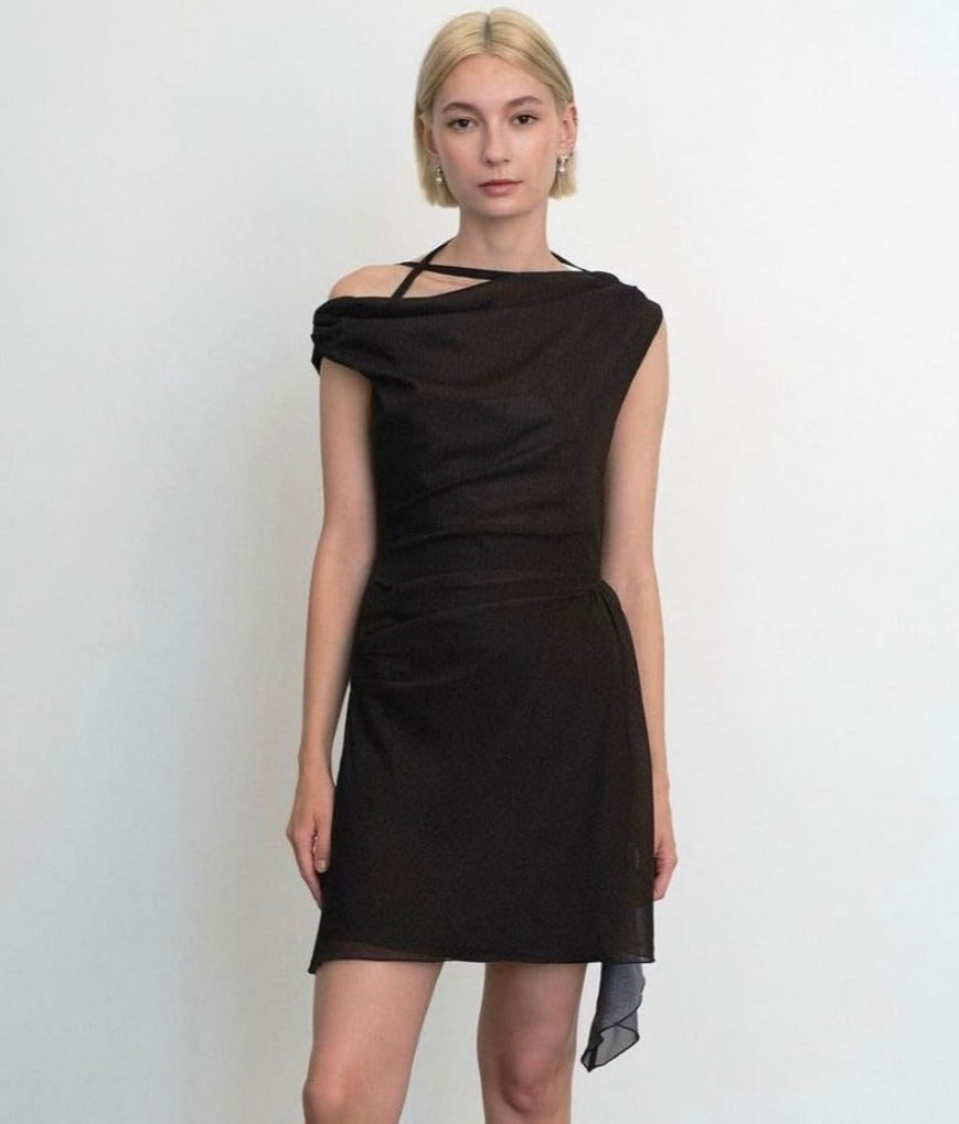 Model wearing a black dress made from deadstock fabric against a white background