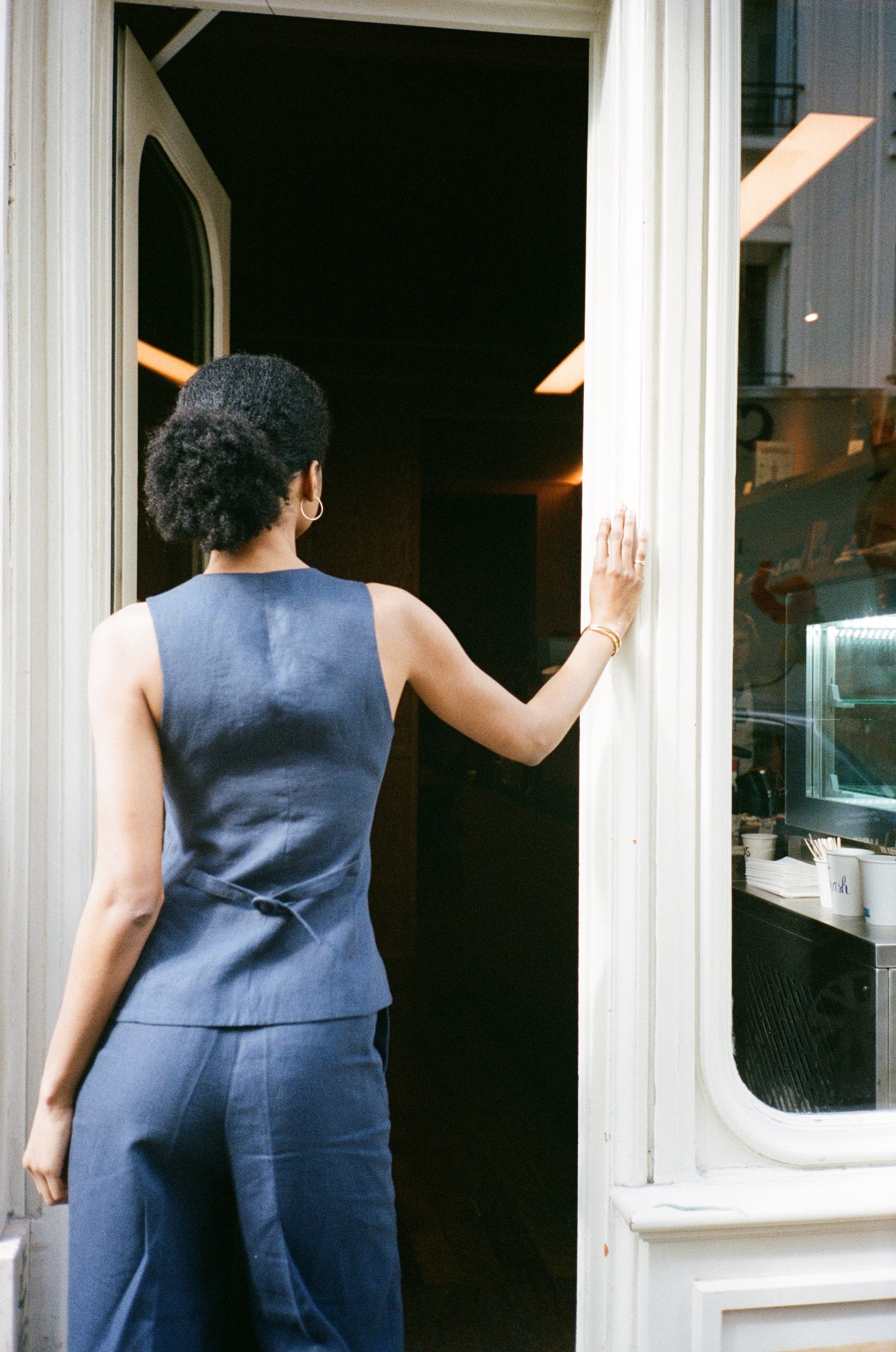 A model wearing the bianca navy blue pants in an aesthetically background. 100% upcycled GOTS certified linen.