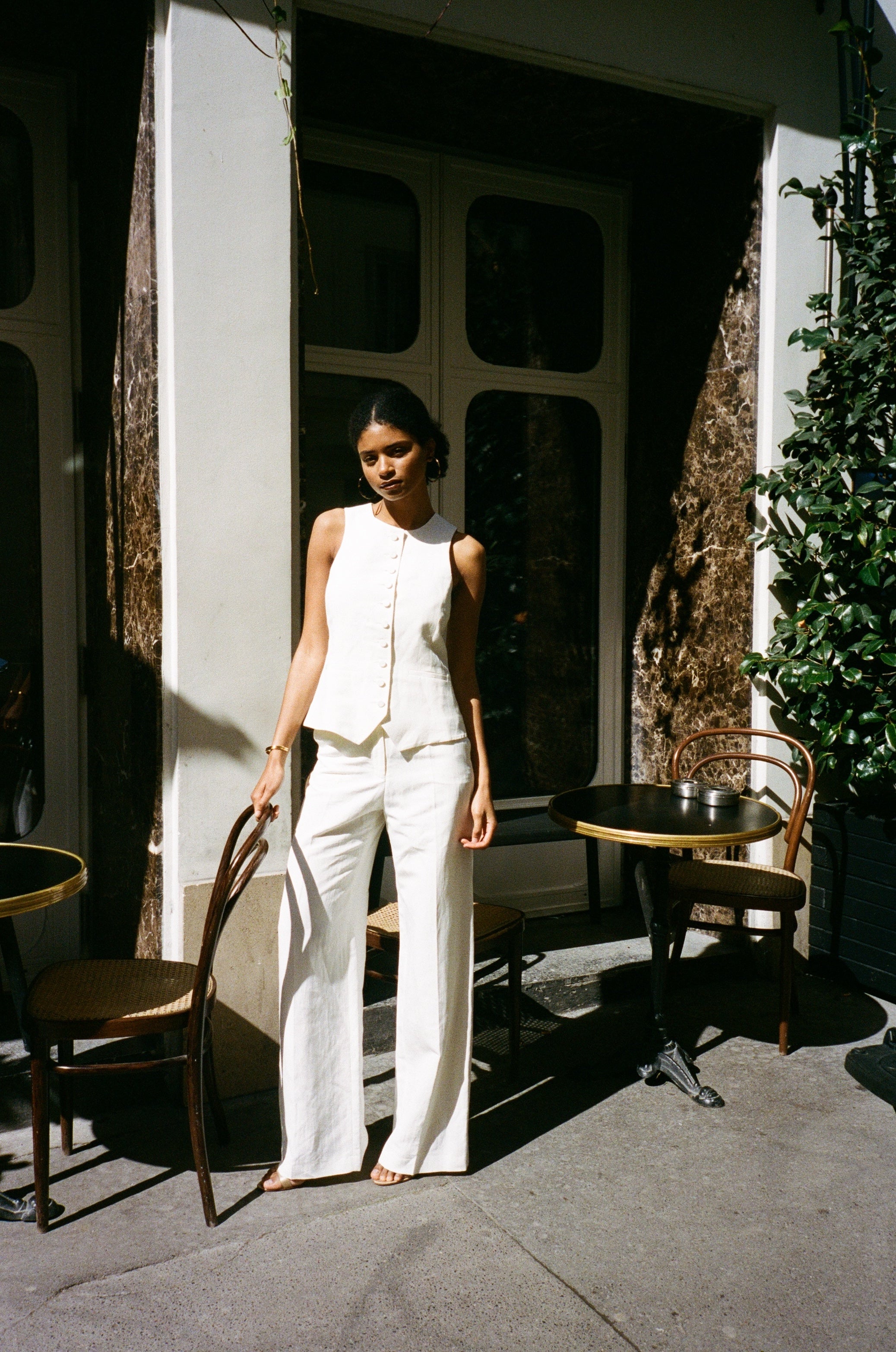 A model wearing the bianca off white pants in an aesthetically background. 100% upcycled linen and silk mix.