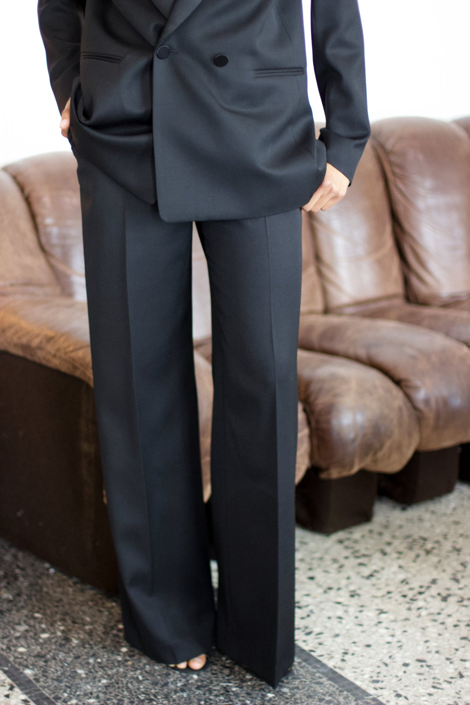 A model wearing the bianca wool and satin smoking pants in an aesthetically background. 100% upcycled wool and silk mix.