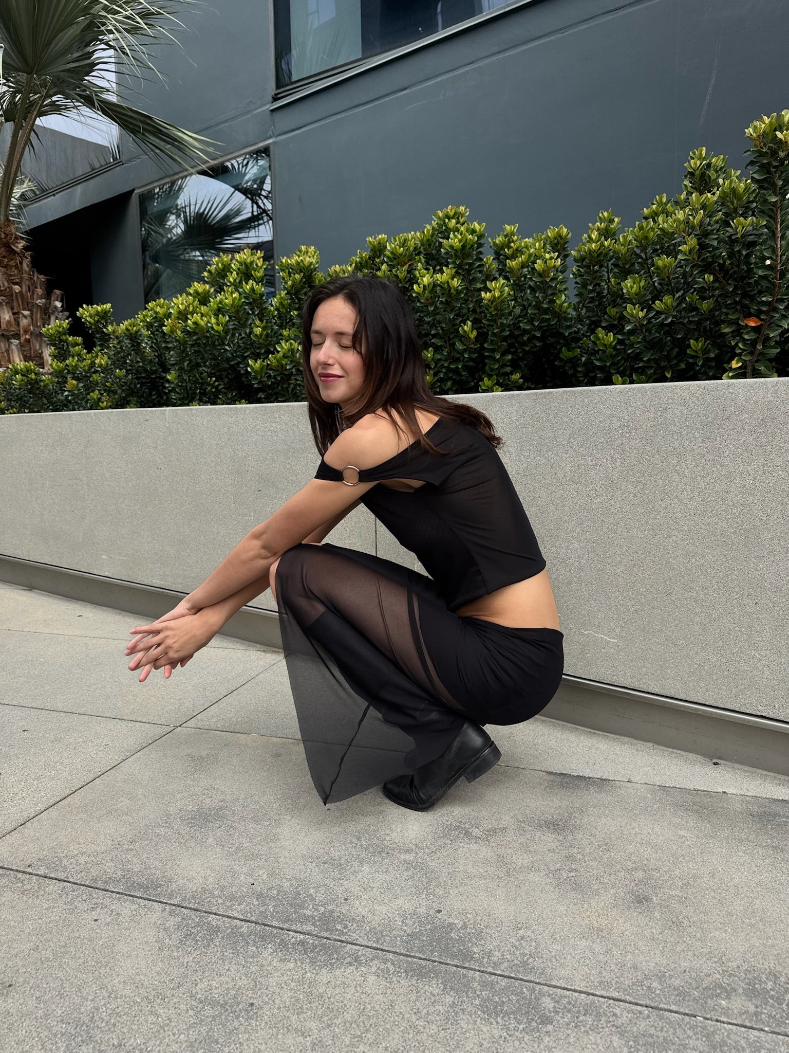 A model wearing the black city skirt in an aesthetically background. 100% made from sustainable deadstock materials.