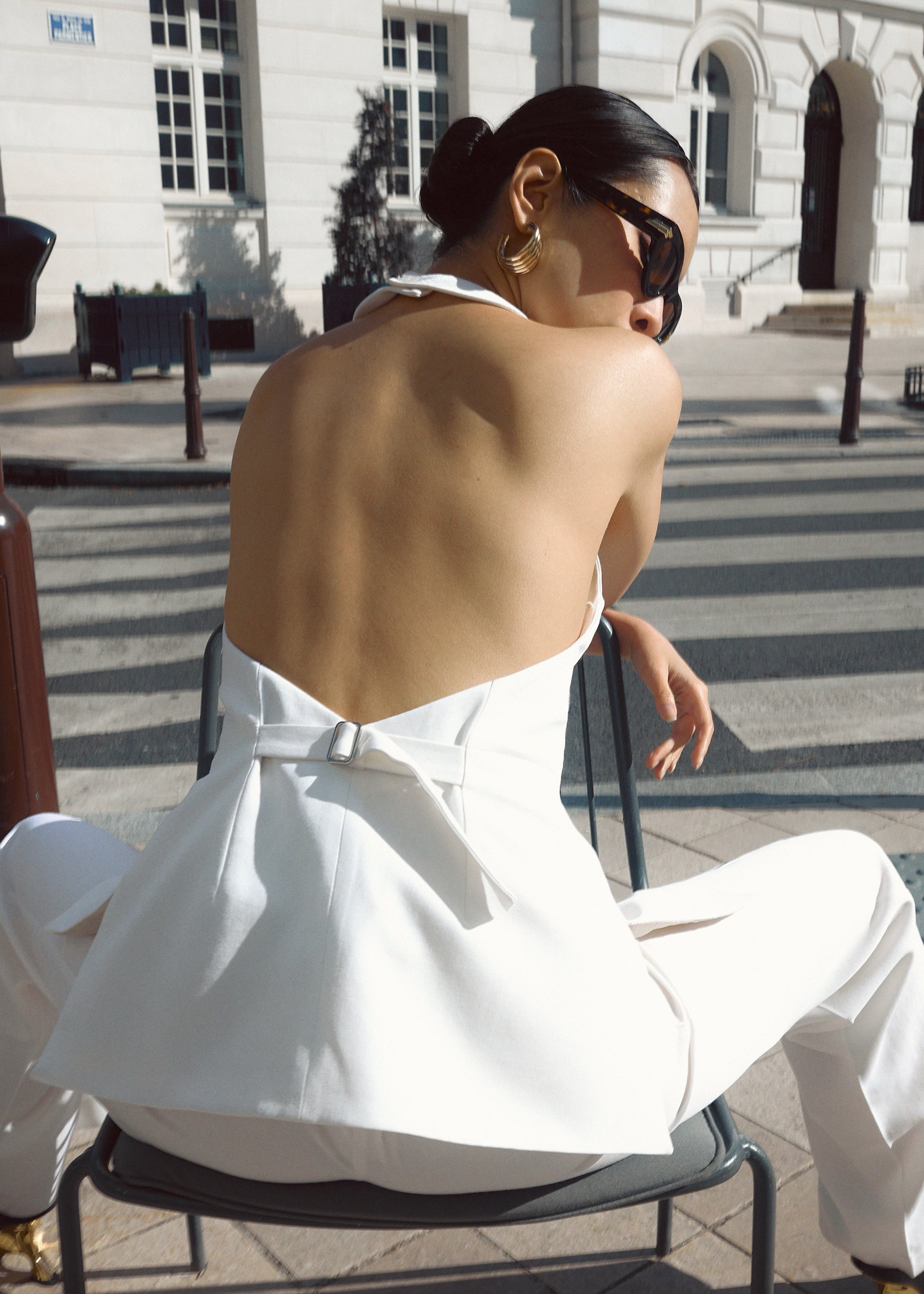 A model wearing the chelsea top in an aesthetically background. 100% sustainable Italian Wool. BACK VIEW.