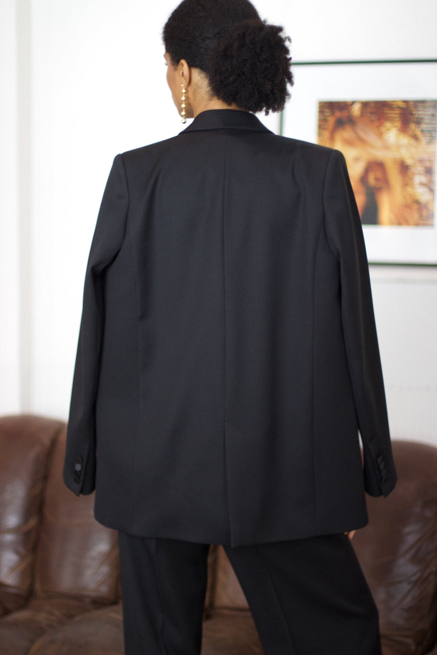 A model wearing the christy wool jacket with black satin collar in an aesthetically background. 100% made from upcycled wool and satin.