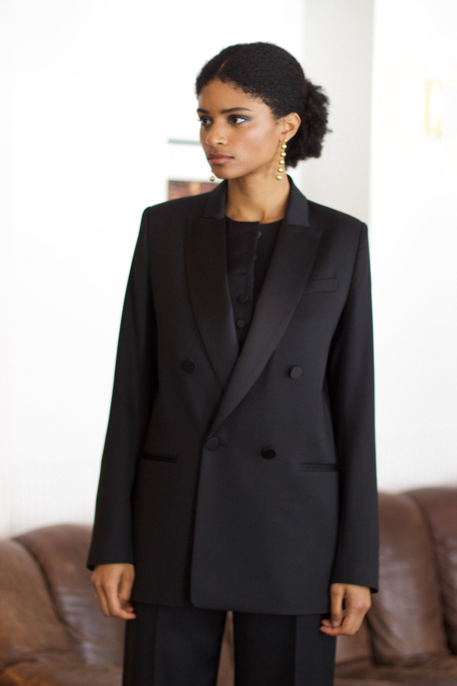 A model wearing the christy wool jacket with black satin collar in an aesthetically background. 100% made from upcycled wool and satin.