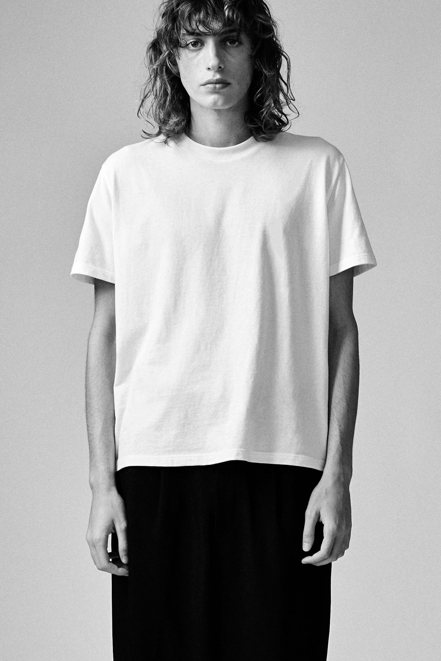 A model wearing the white classic tee in a white background. 100% made from organic grown cotton.