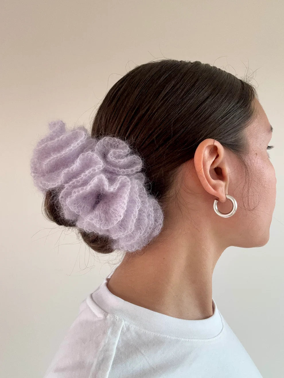 A model wearing the cleo scrunchie in a white background. Handmade in London!