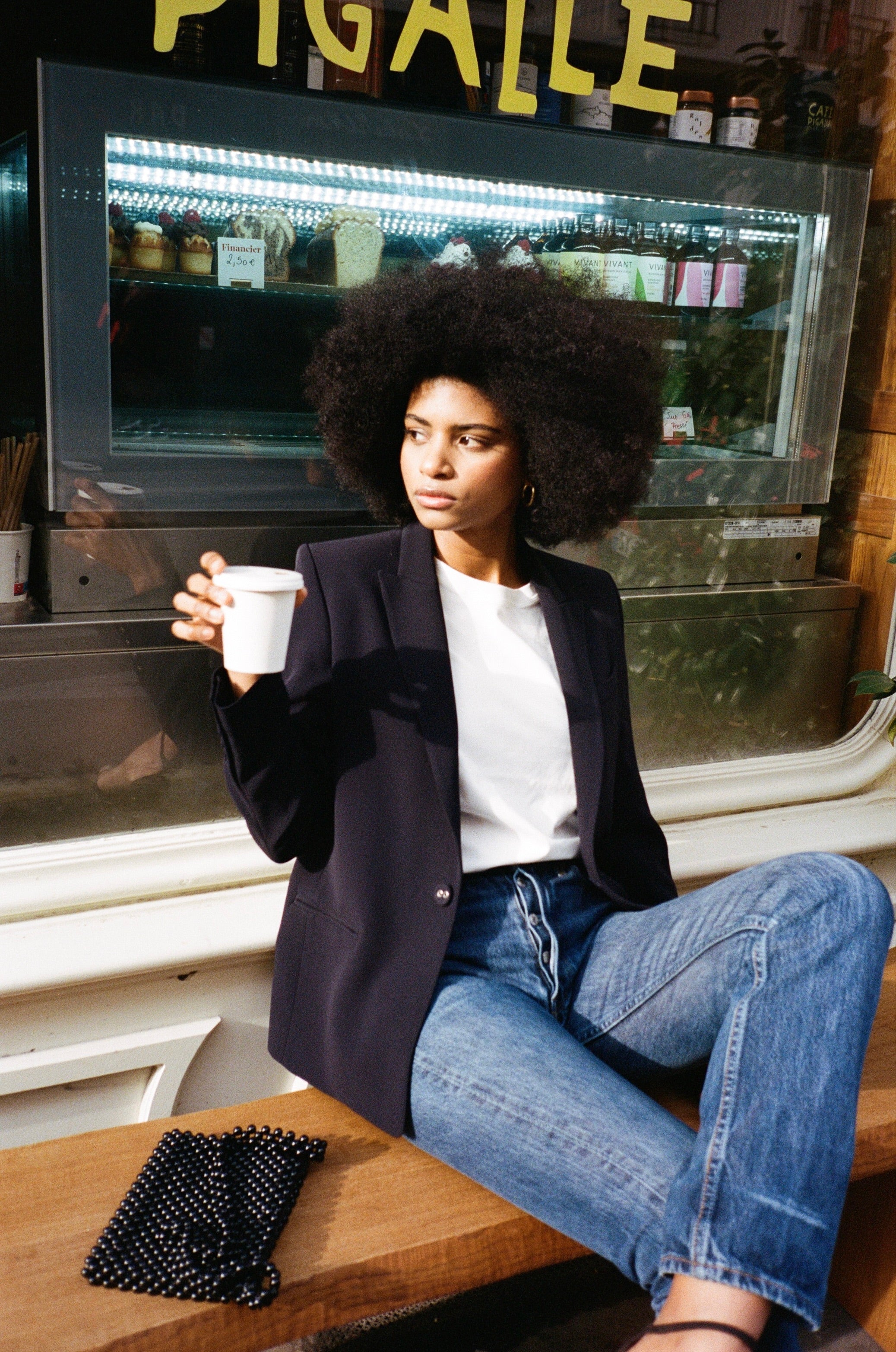 A model wearing the diana midnight blue blazer in an aesthetically outside background. 100% made from sustainable wool.