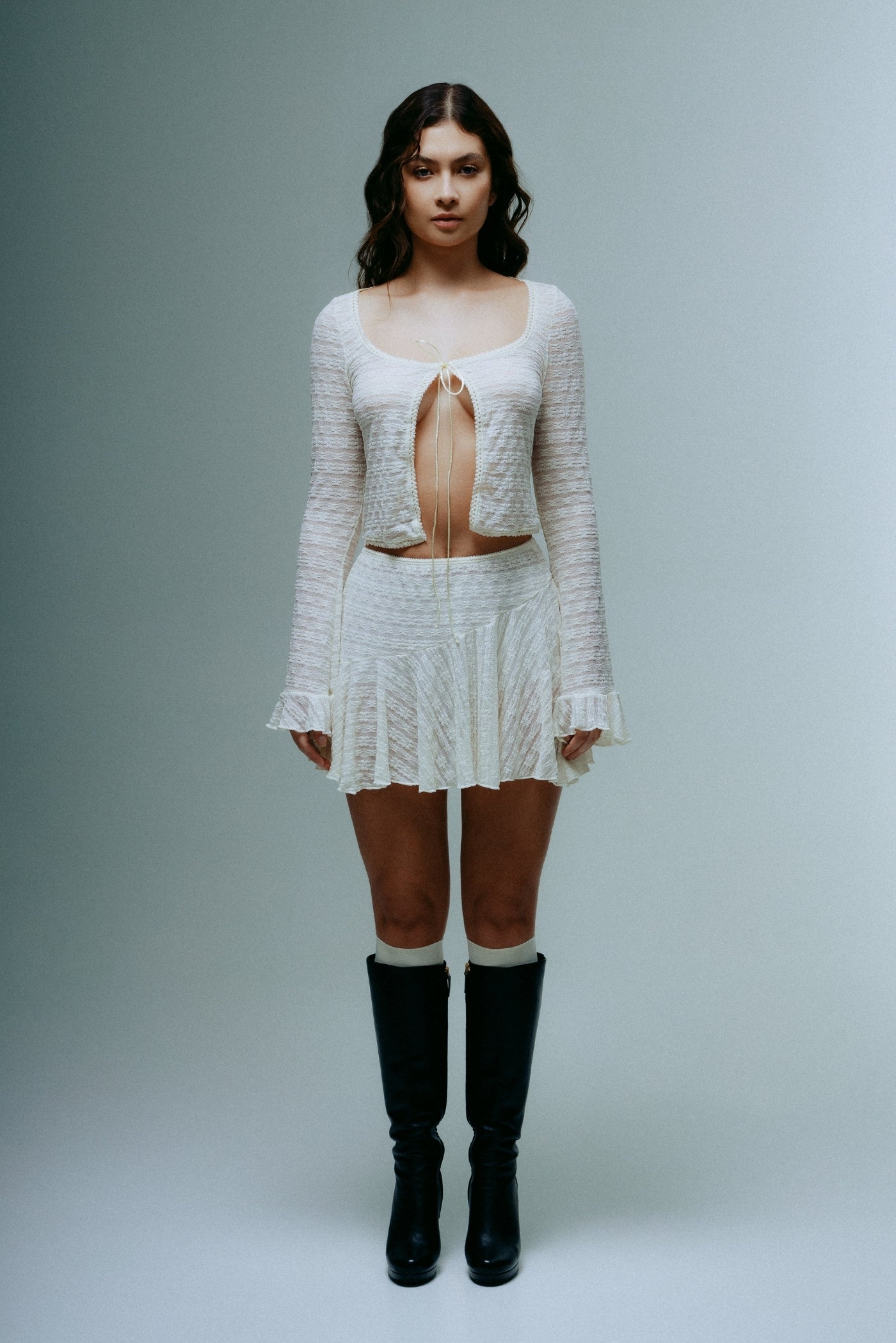 A model wearing the dreamwave mini skirt in a white background. 100% deadstock lace material.