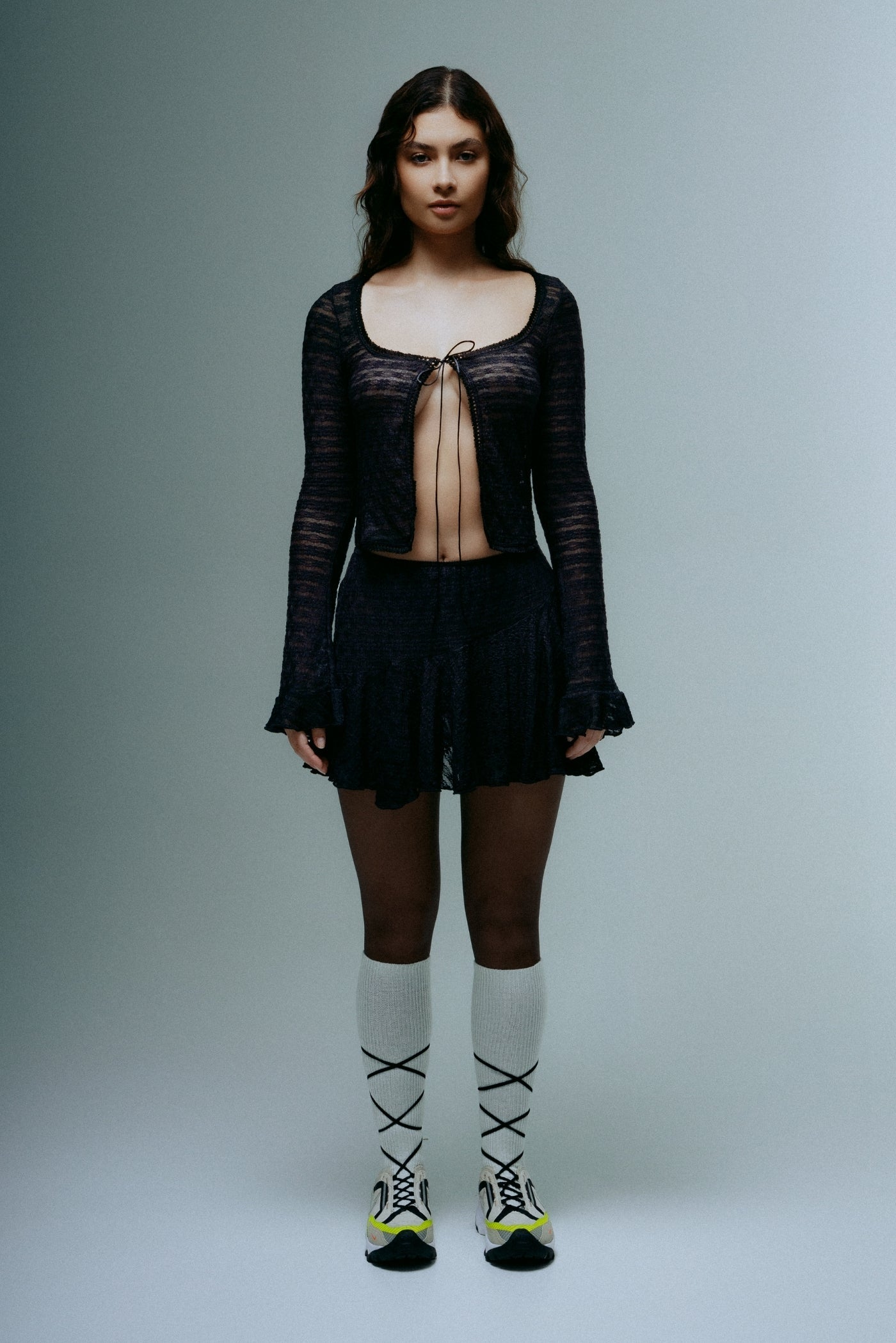 A model wearing the dreamwave mini skirt in a white background. 100% deadstock lace material.