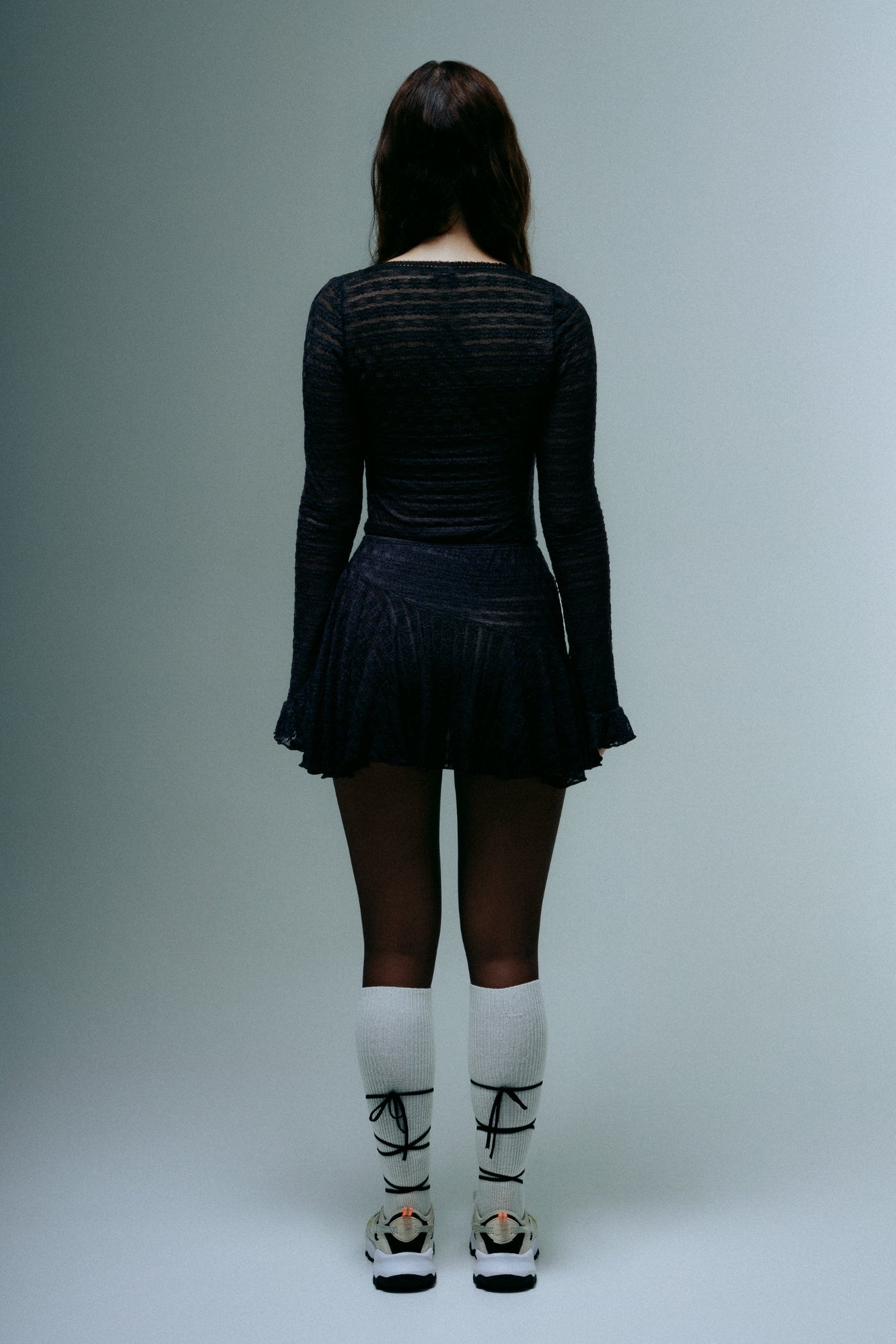 A model wearing the dreamwave mini skirt in a white background. 100% deadstock lace material.