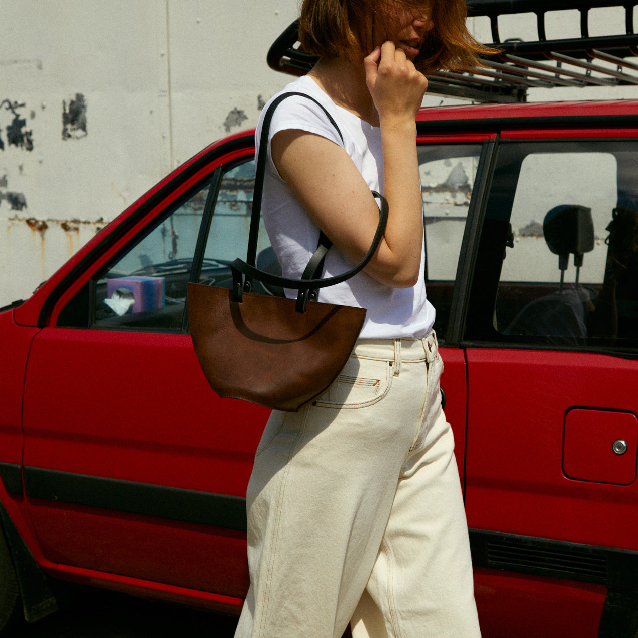 A model wearing the elwin bag in an aesthetically background. Crafted from chrome-free leather.