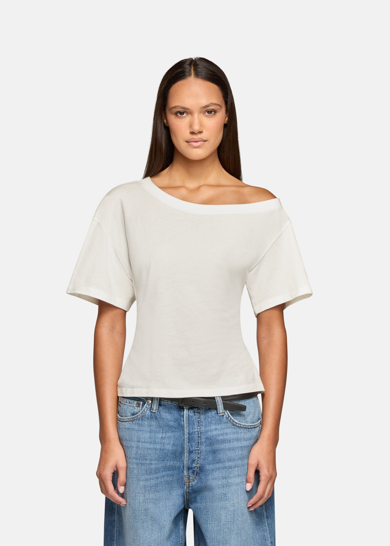 A model wearing the white elena off shoulder tee in a white background. 100% made from cotton.