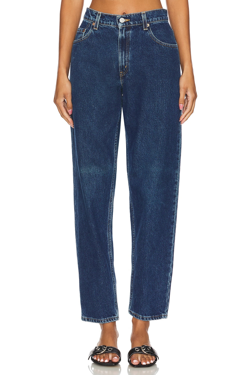 Model wearing the high rise slim customs in a white background. 100% made from repurposed Levi’s.