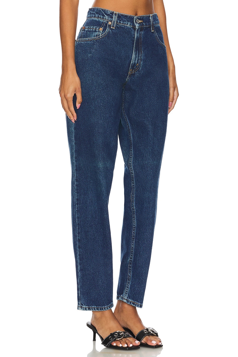 Model wearing the high rise slim customs in a white background. 100% made from repurposed Levi’s.