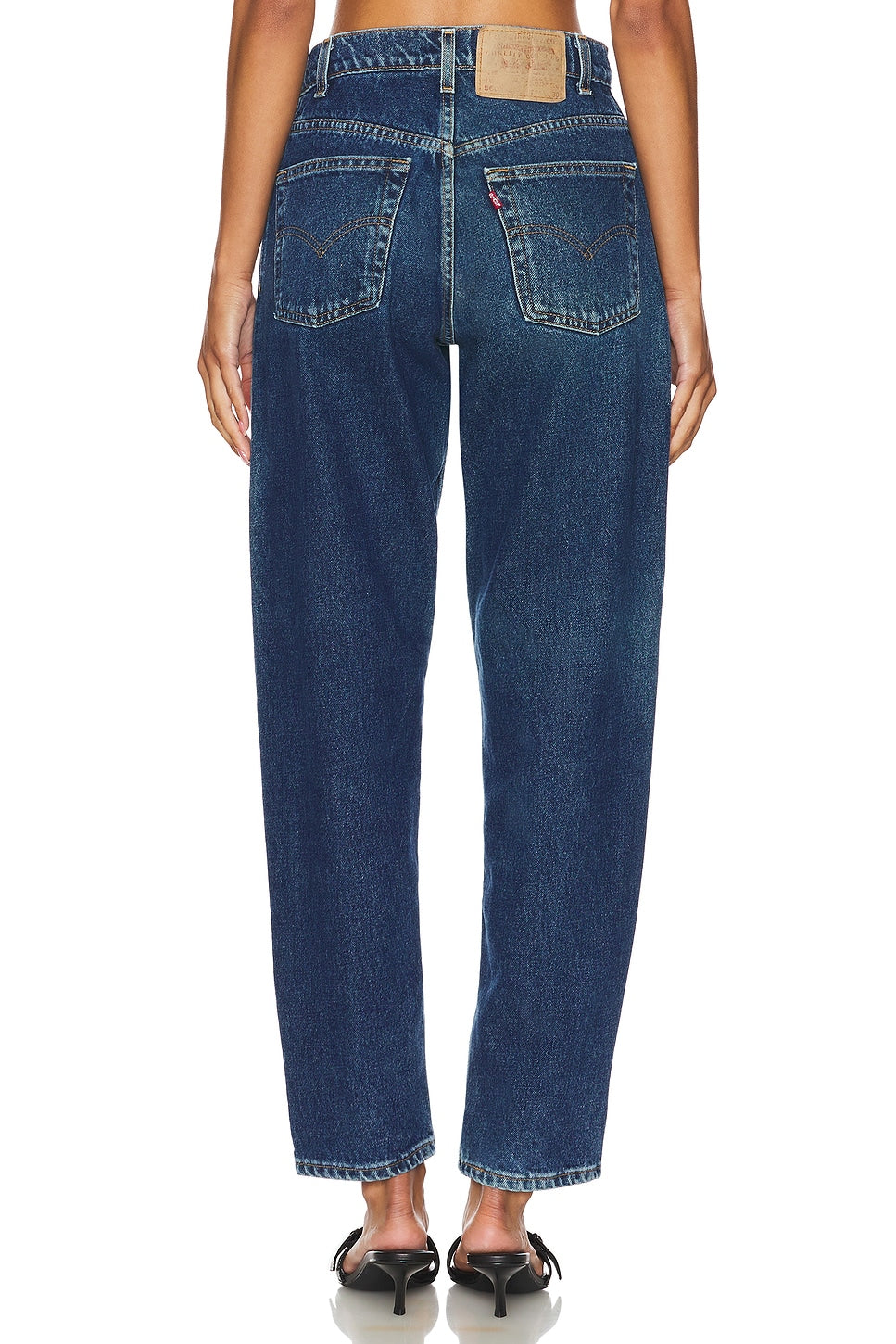 Model wearing the high rise slim customs in a white background. 100% made from repurposed Levi’s.