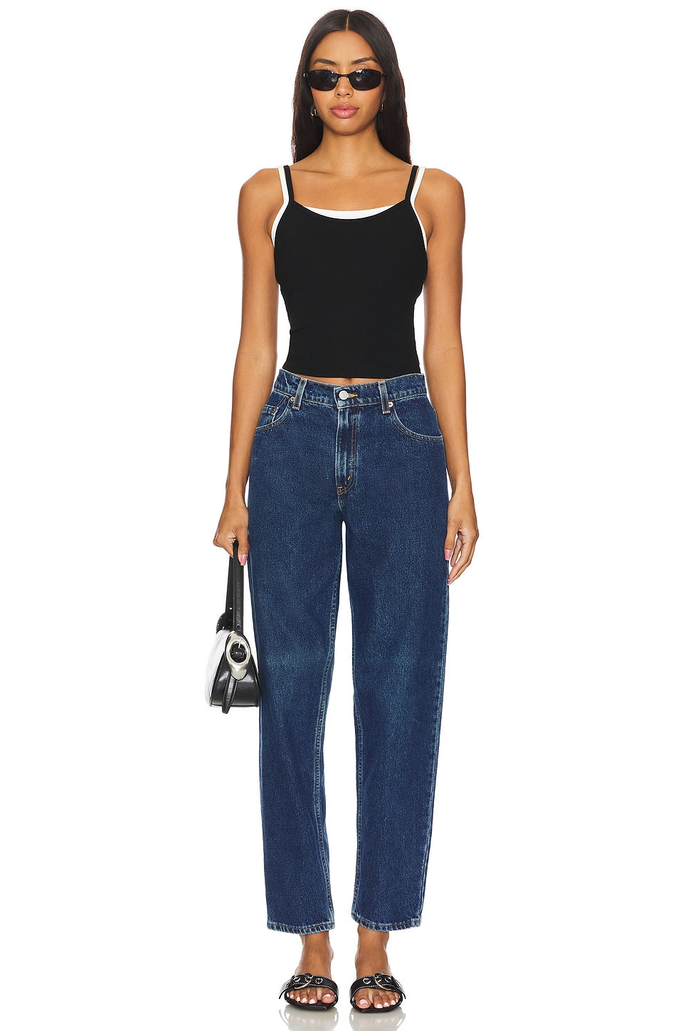 Model wearing the high rise slim customs in a white background. 100% made from repurposed Levi’s.