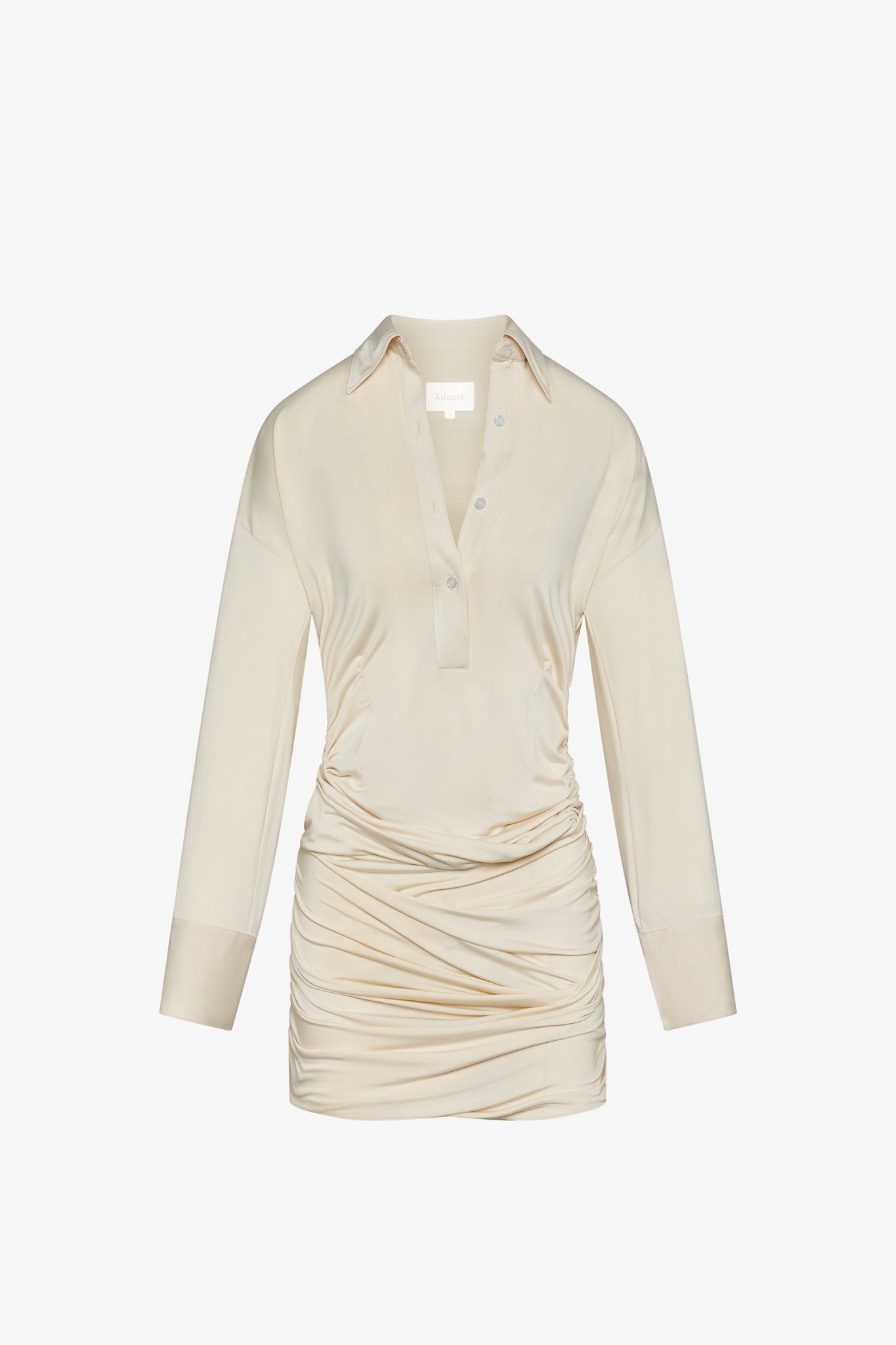 A cream, mini-length long sleeve dress with buttons and collar in a white background. Made from sustainable deadstock materials.