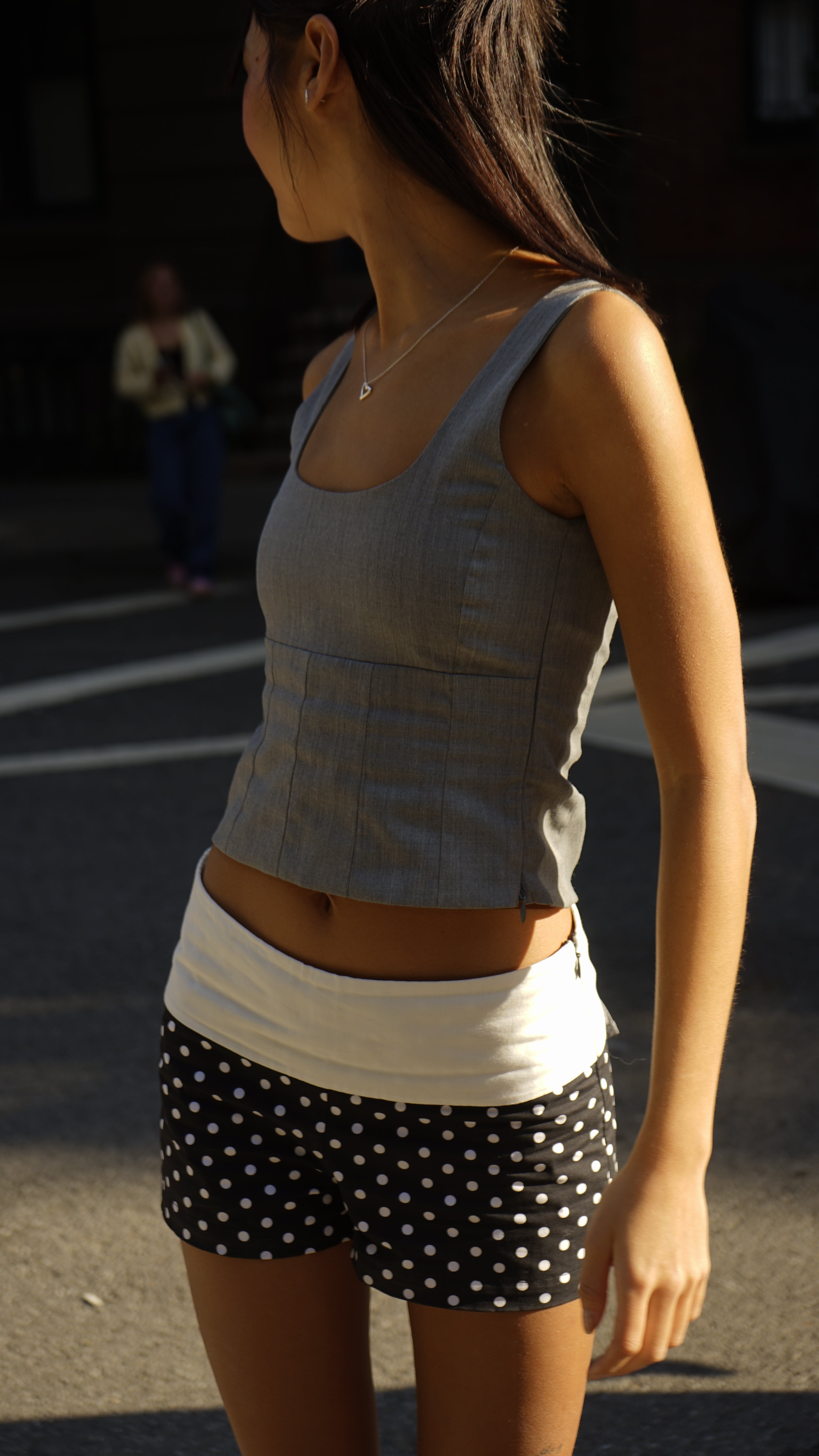 A model wearing the Kaia top in an aesthetically background. 100% made from sustainable deadstock materials.