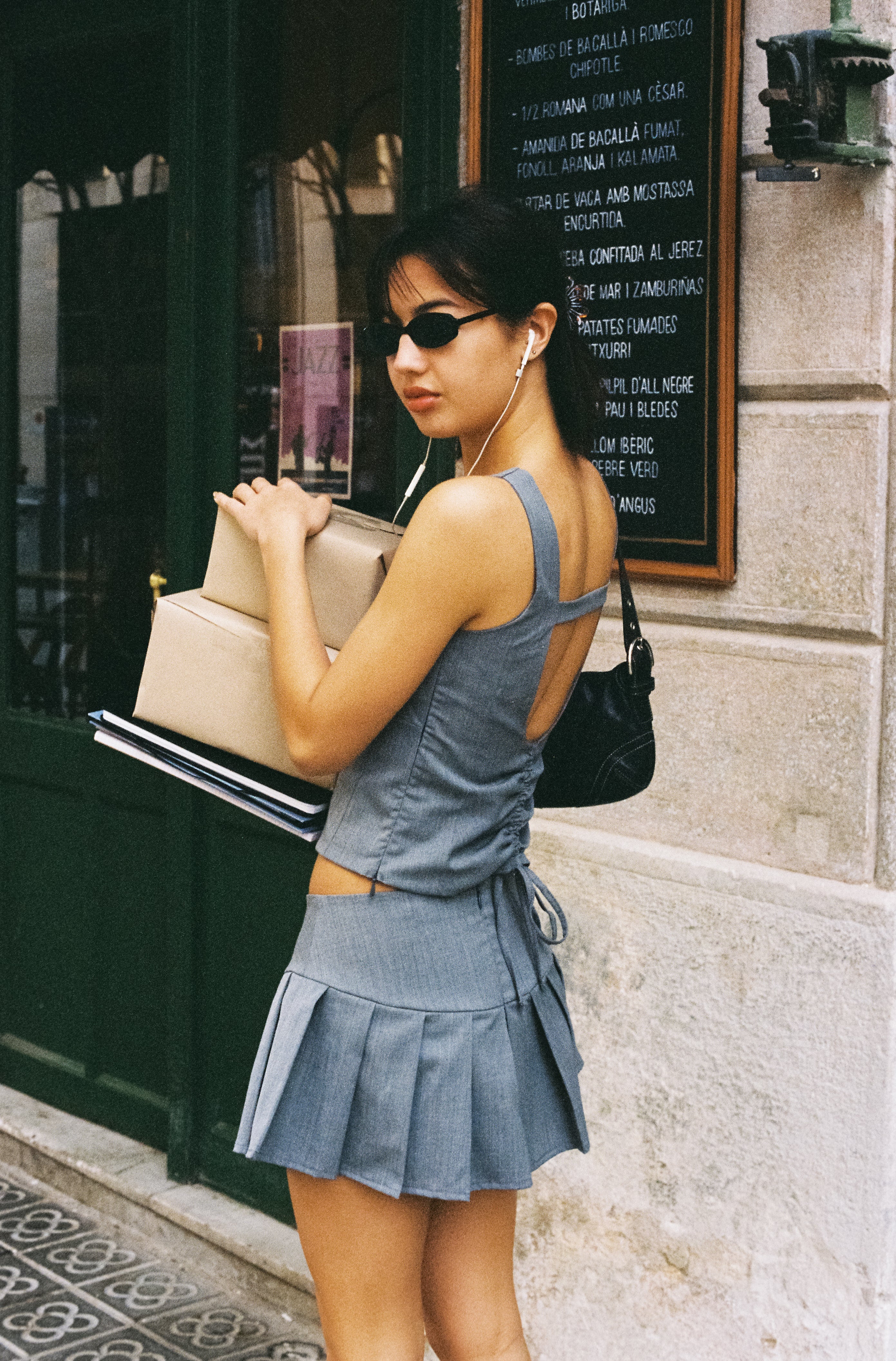 A model wearing the Kaia top in an aesthetically background. 100% made from sustainable deadstock materials.