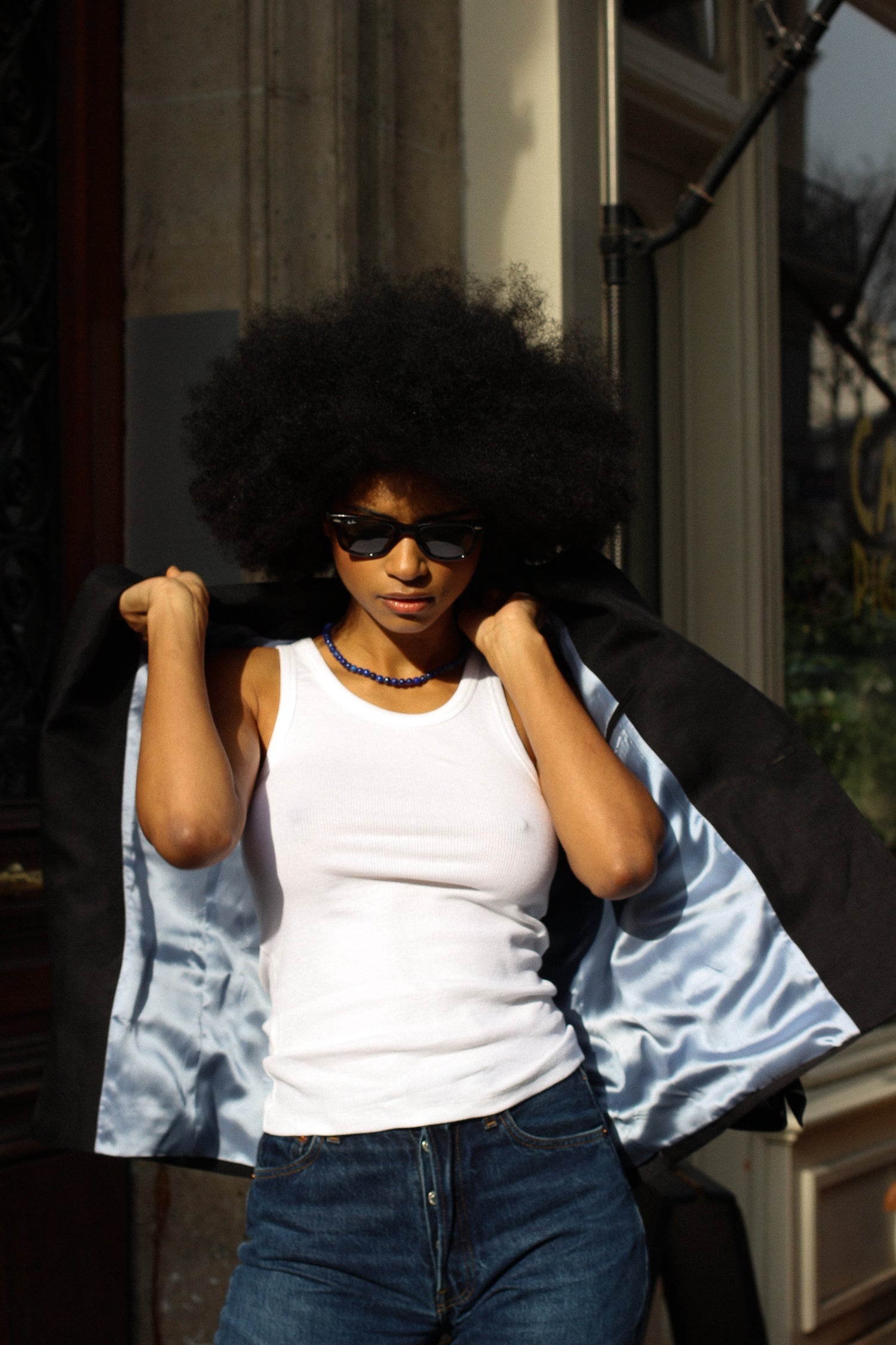 A model wearing the lauren black linen twill blazer in an aesthetically background. 100% upcycled GOTS certified linen.