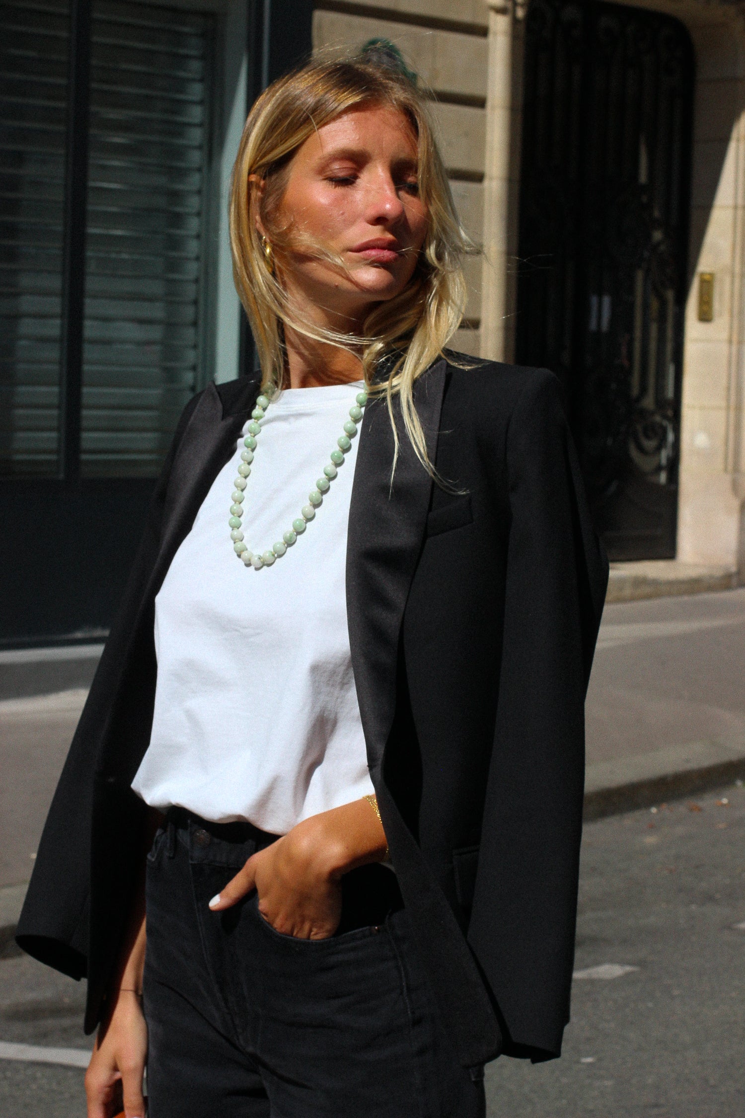 A model wearing the lauren black wool tuxedo blazer in an aesthetically outside background. 100% made from sustainable wool.