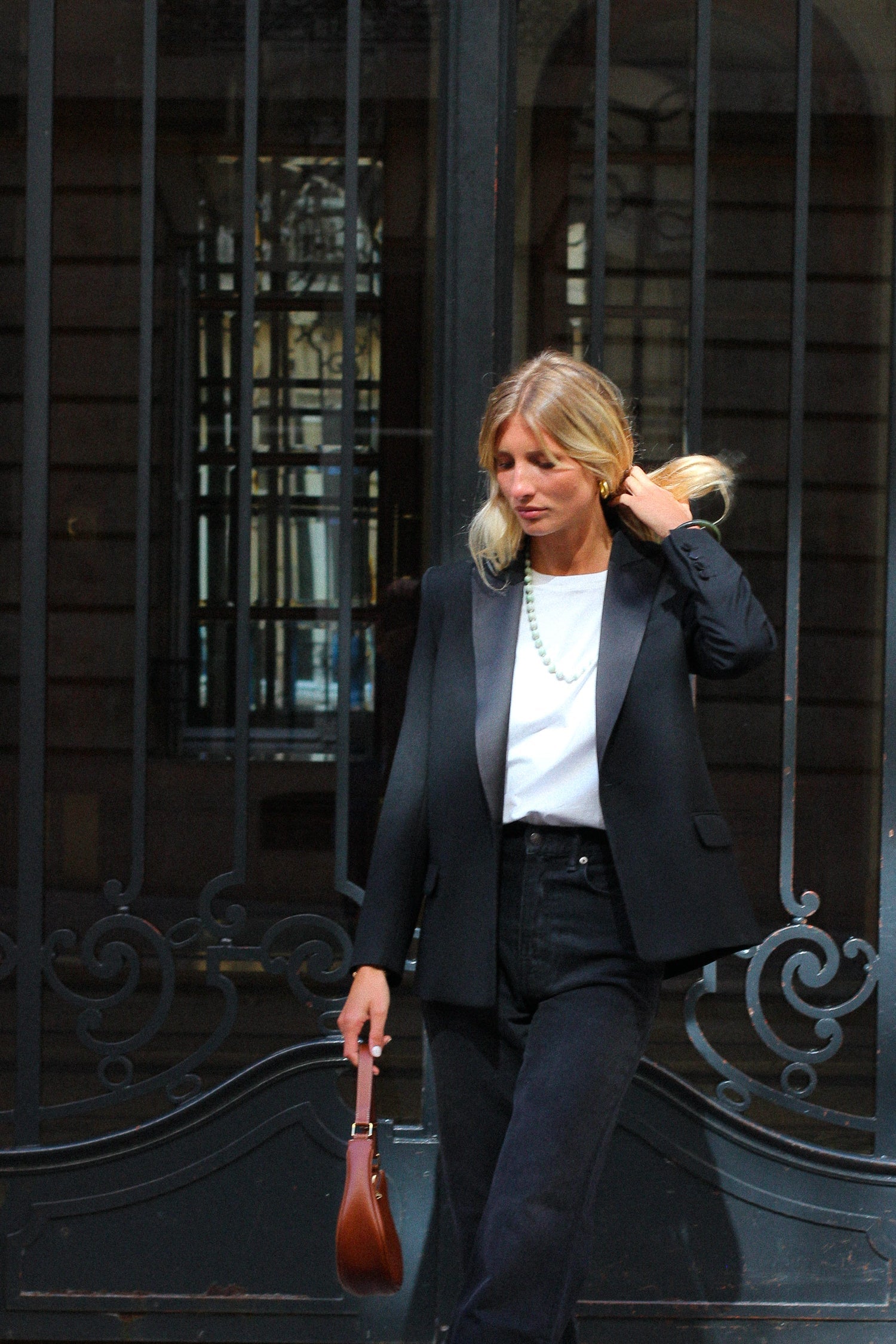 A model wearing the lauren black wool tuxedo blazer in an aesthetically outside background. 100% made from sustainable wool.