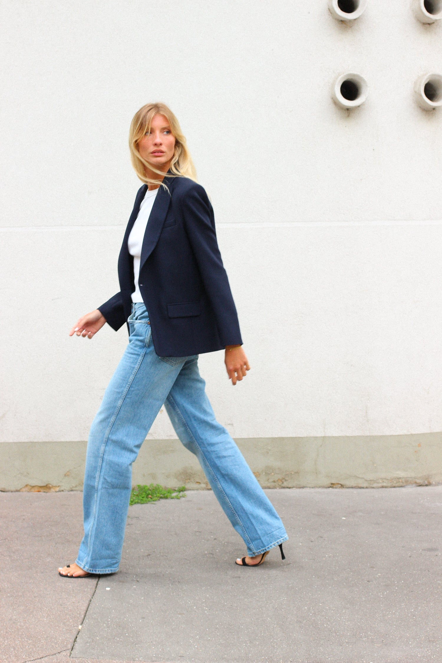 A model wearing the lauren midnight blue wool blazer in a white background. 100% made from sustainable upcycled wool.