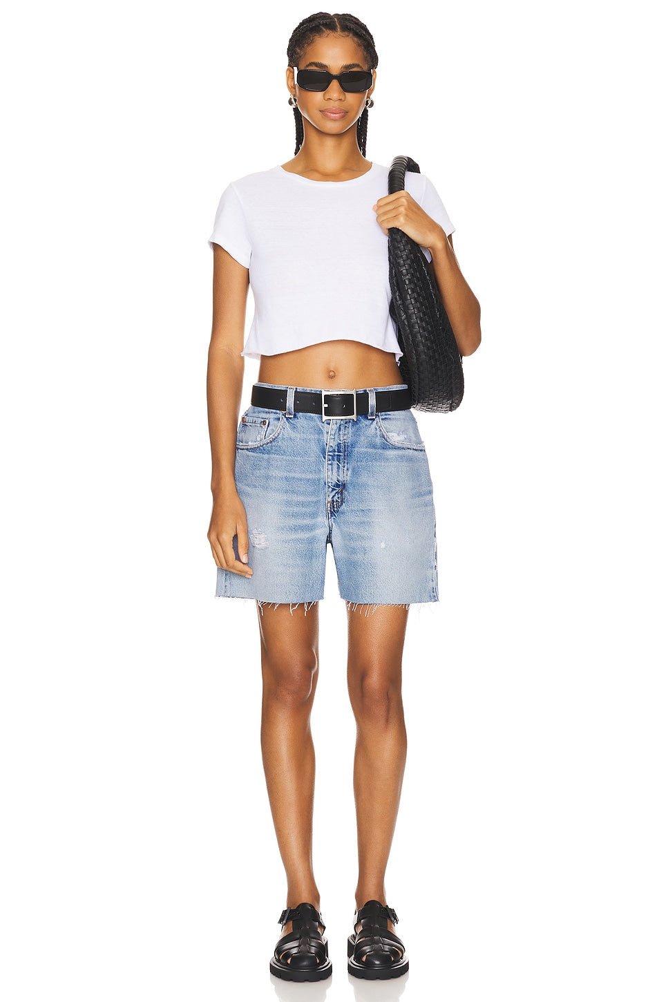 Model wearing a long baggy short in a white background. 100% made from repurposed Levi’s.