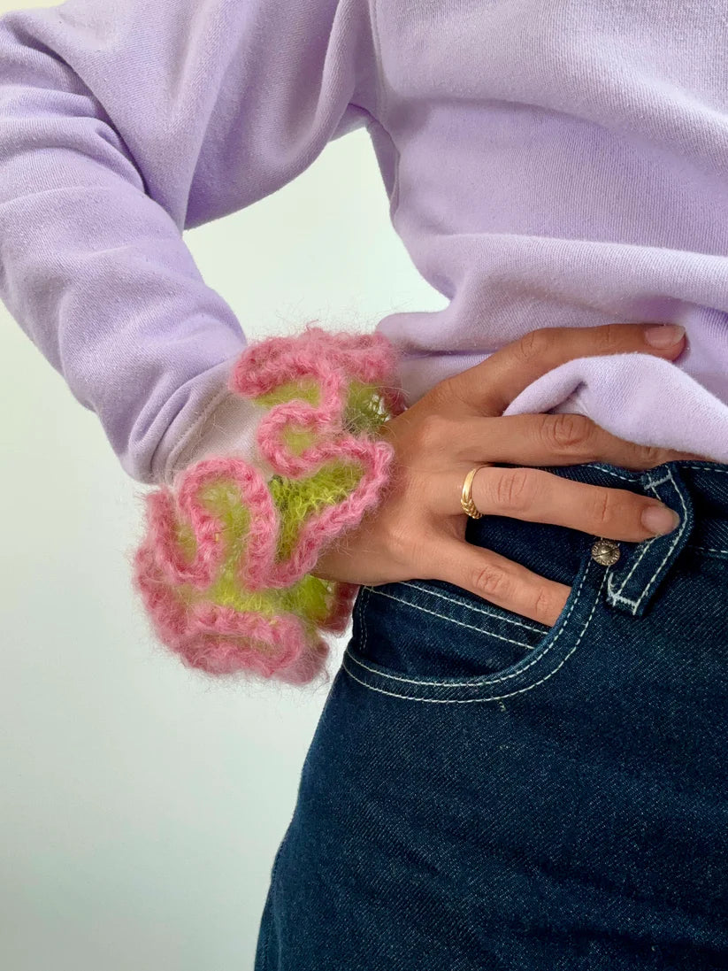 A model wearing the maeve scrunchie on her hand in a white background. Handmade in London!