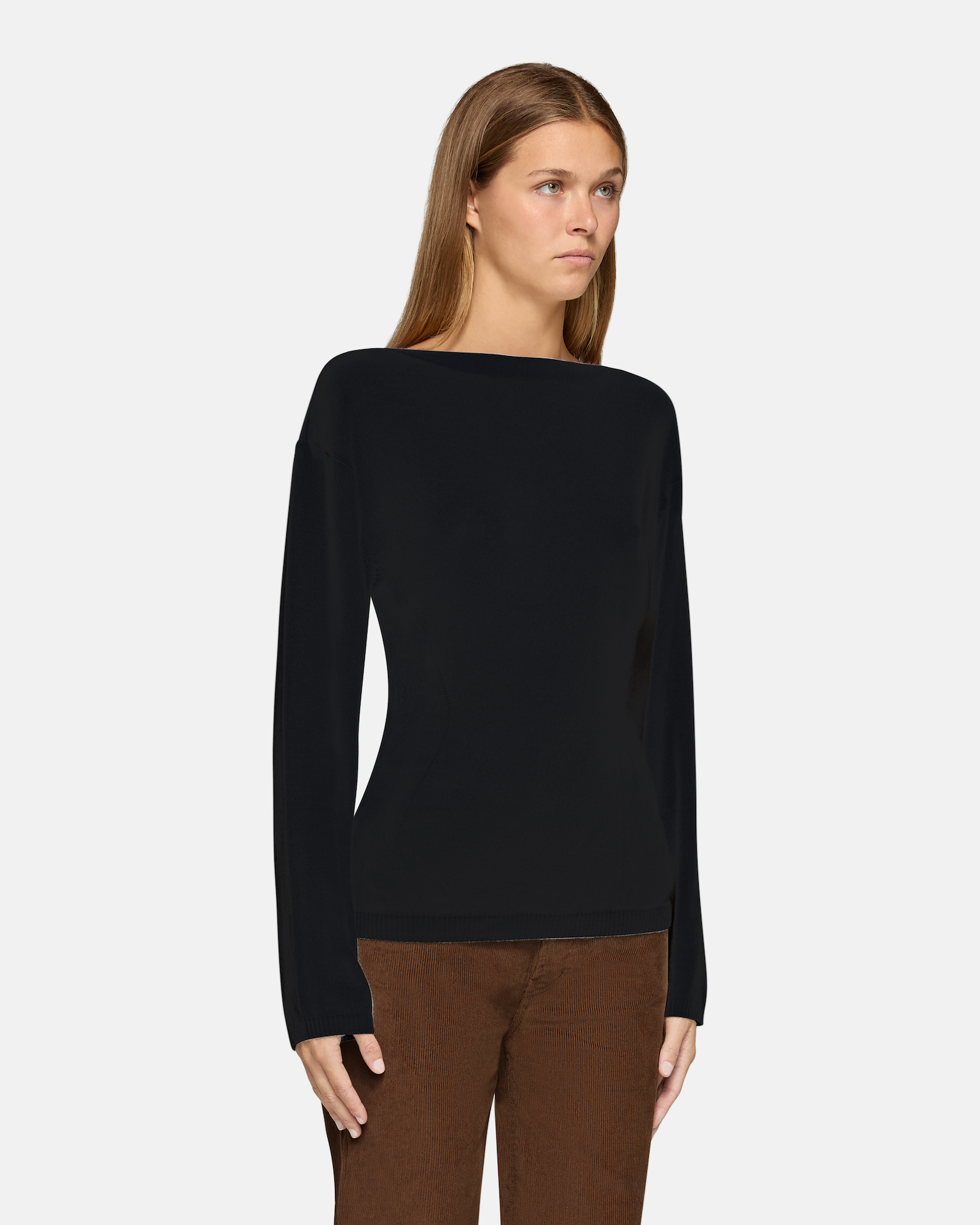 A model wearing the millie boat neck sweater in black in a white background. 100% made from cotton.