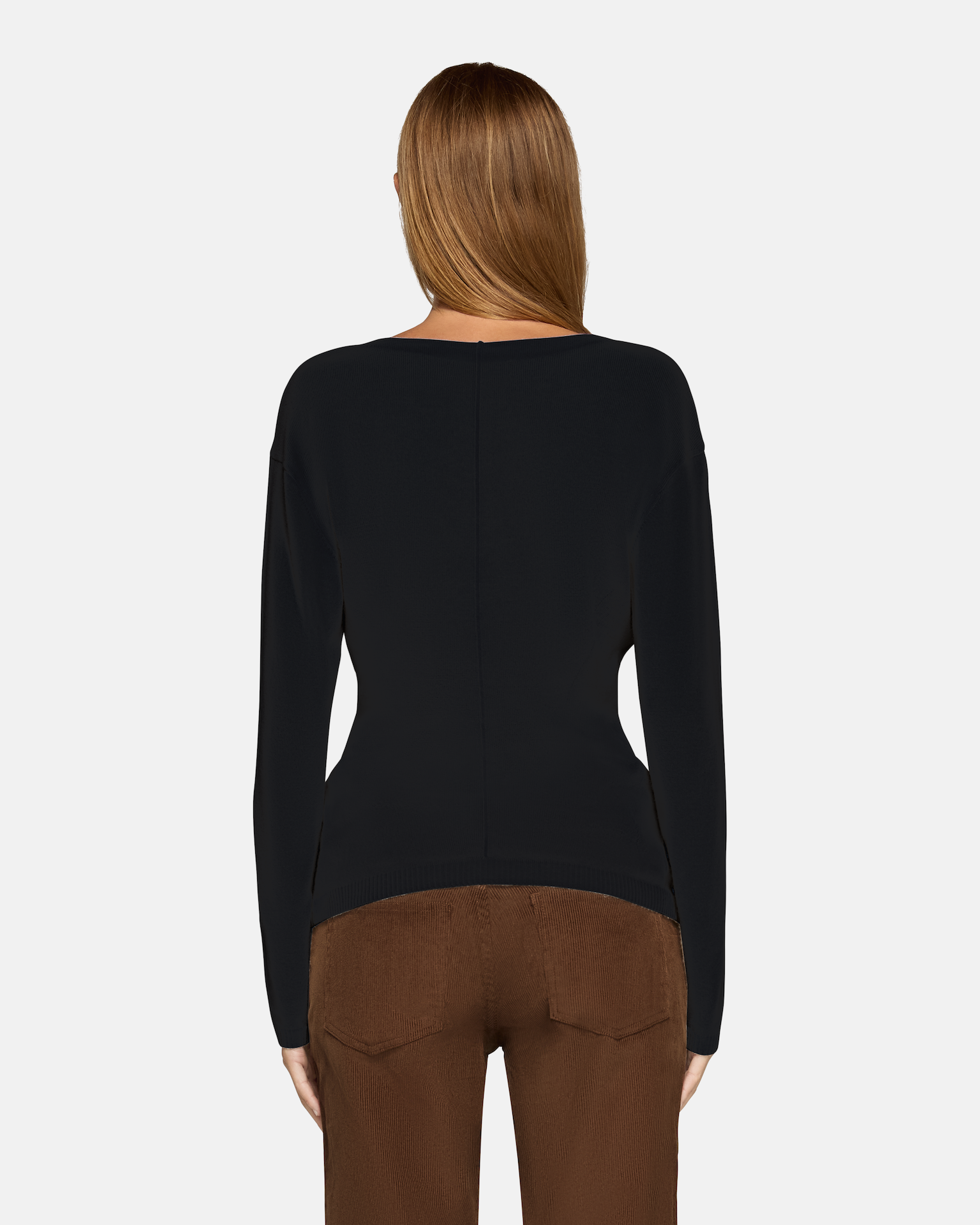 A model wearing the millie boat neck sweater in black in a white background. 100% made from cotton.