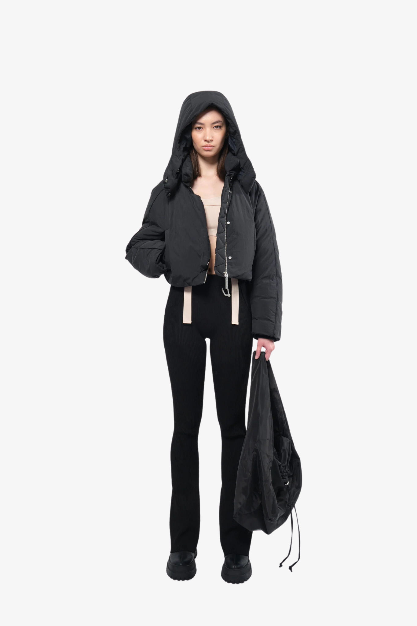 Model wearing a crop puffer jacket in a white background. 100% made from recycled fabric.