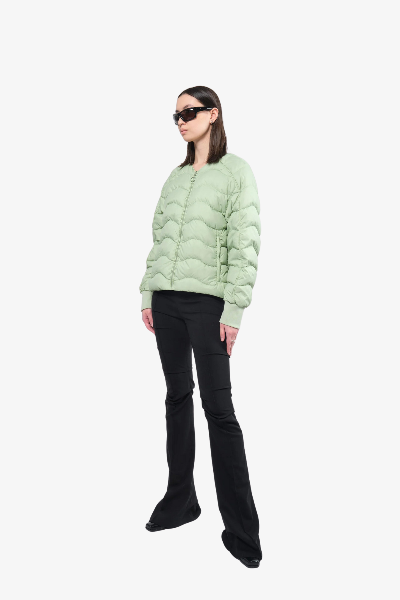 Model wearing a light puffer jacket in a white background. 100% made from recycled fabric.