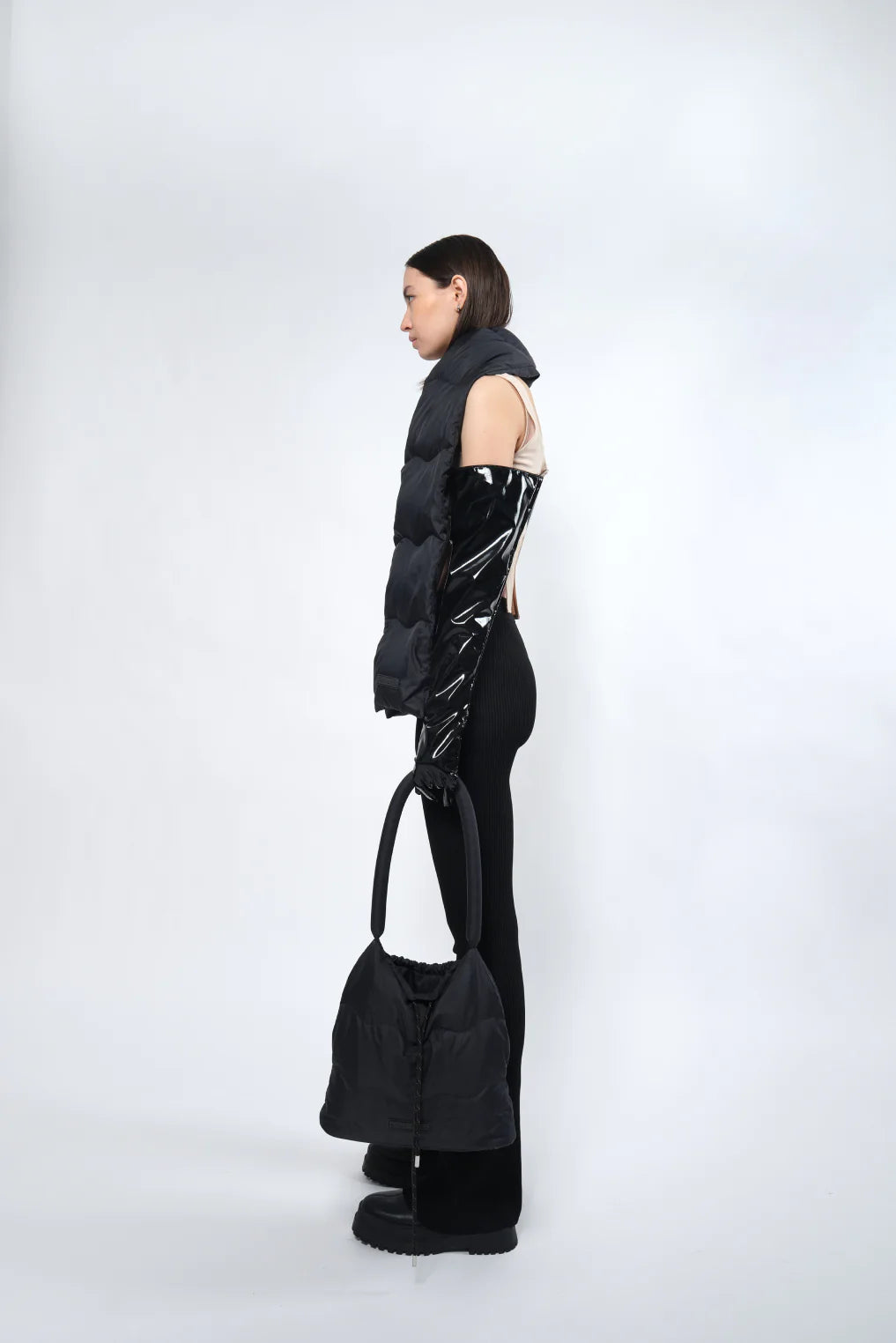 Model wearing a puffered scarf in a white background. 100% made from recycled fabric.