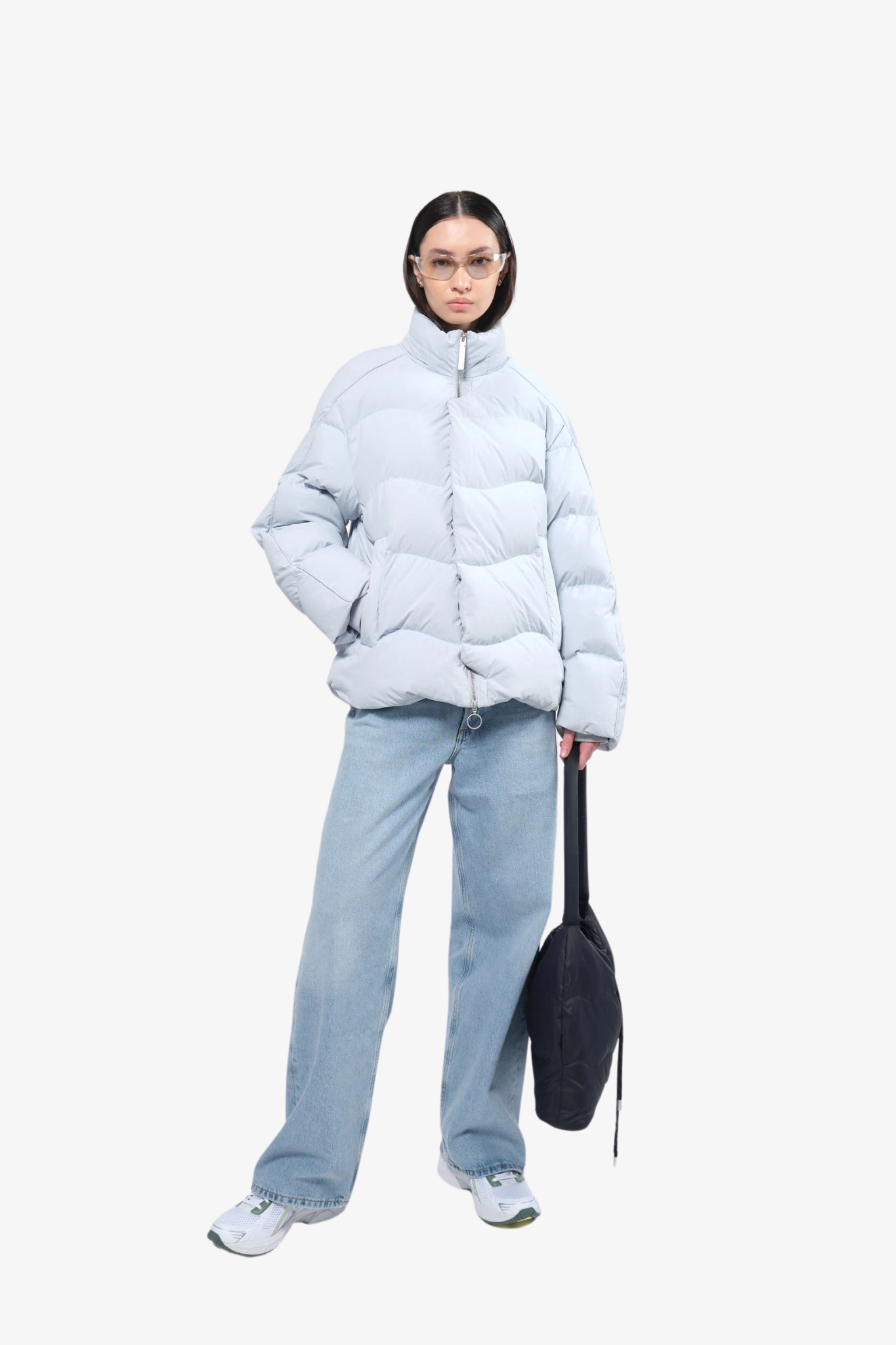 Model wearing a puffer jacket in a white background. 100% made from recycled fabric.