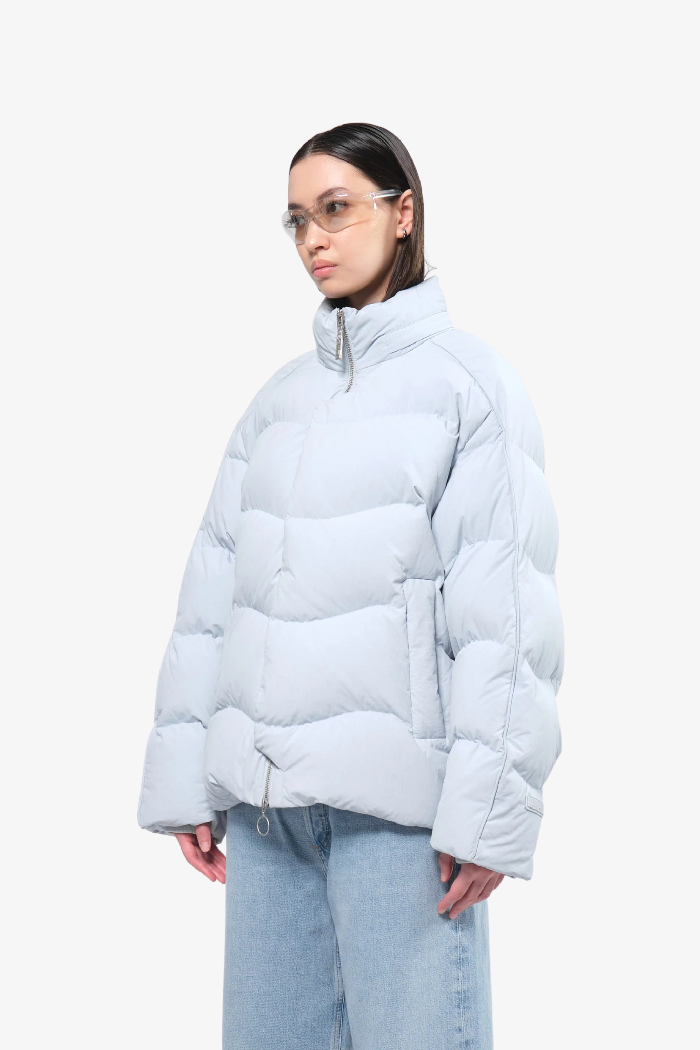 Model wearing a puffer jacket in a white background. 100% made from recycled fabric.