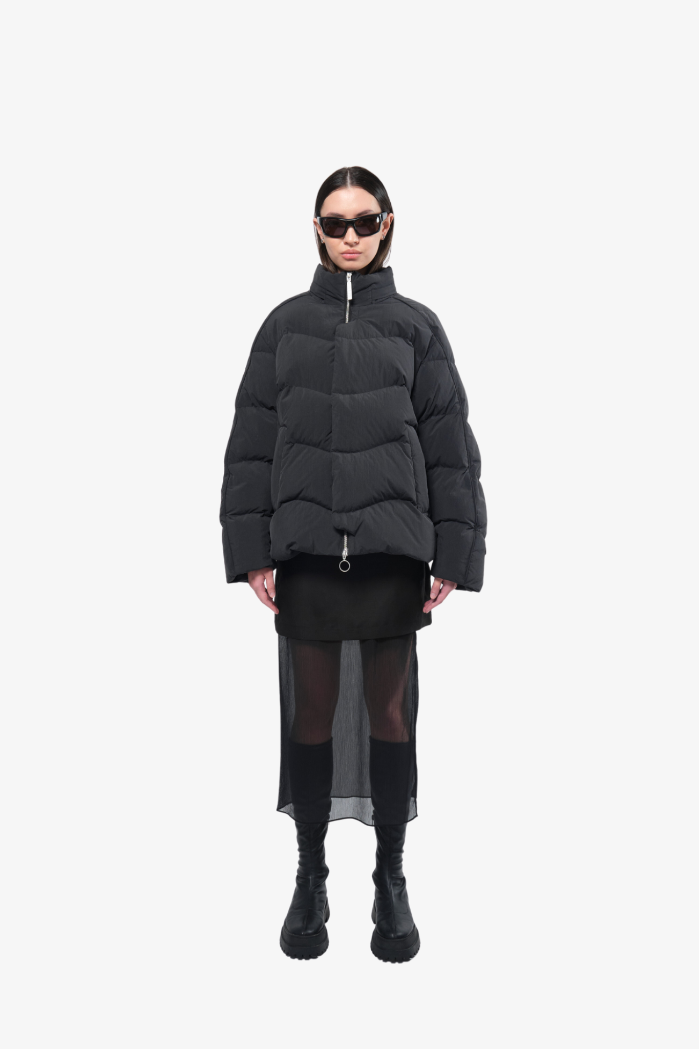 Model wearing a puffer jacket in a white background. 100% made from recycled fabric.
