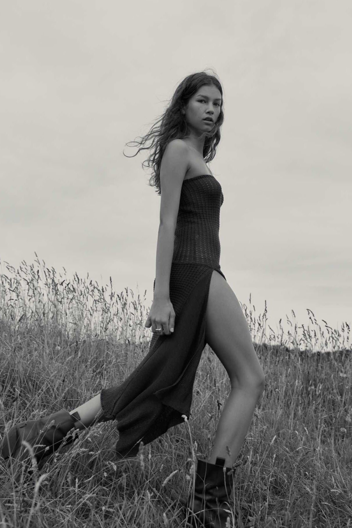 A model wearing the selene dress in an aesthetically outside background. 100% brown cotton knit.