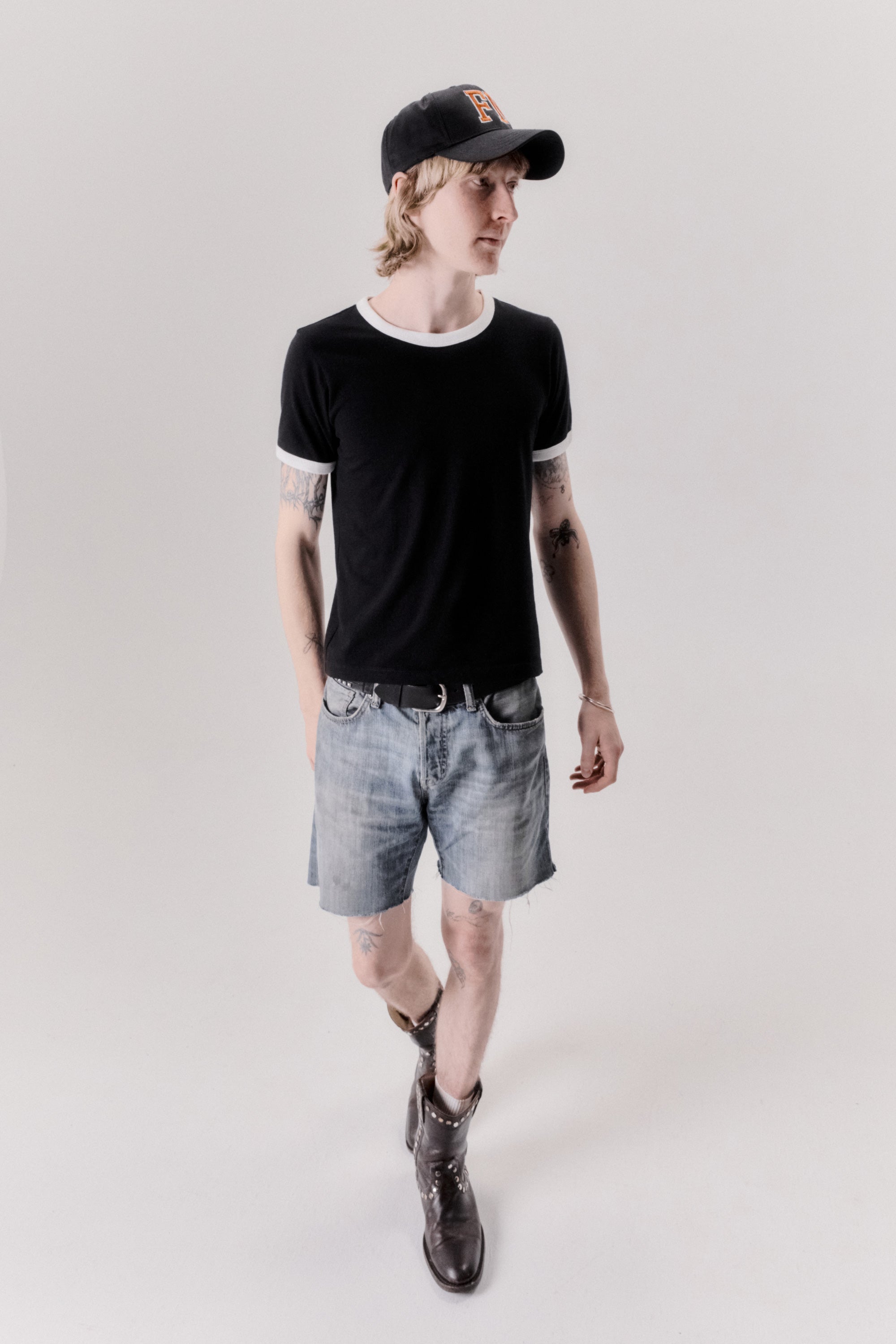 A model wearing the star ringer tshirt in black with white contrast in a white background. 100% made from organic grown cotton.