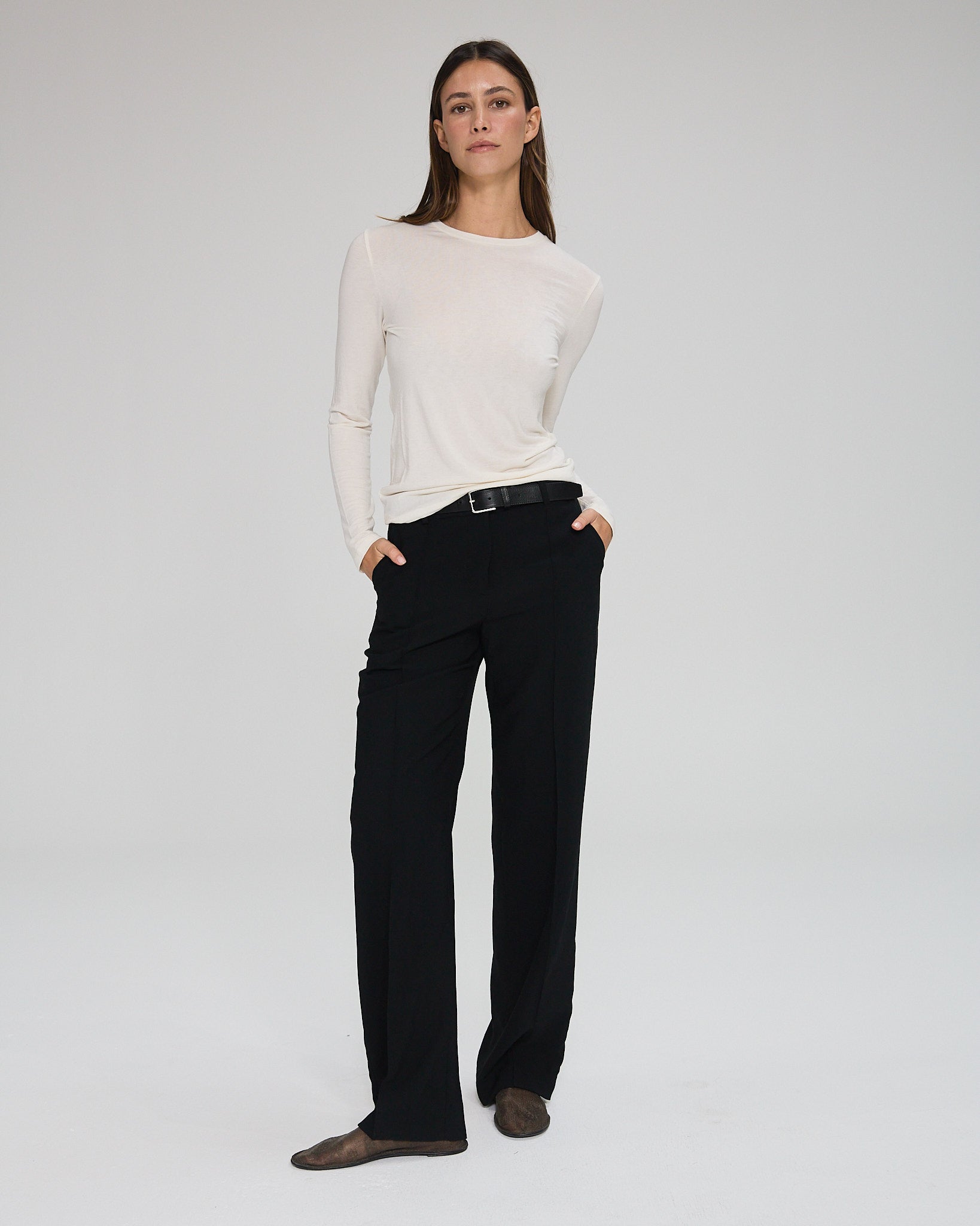 Model wearing black trousers in a white background. Made from sustainable deadstock materials.
