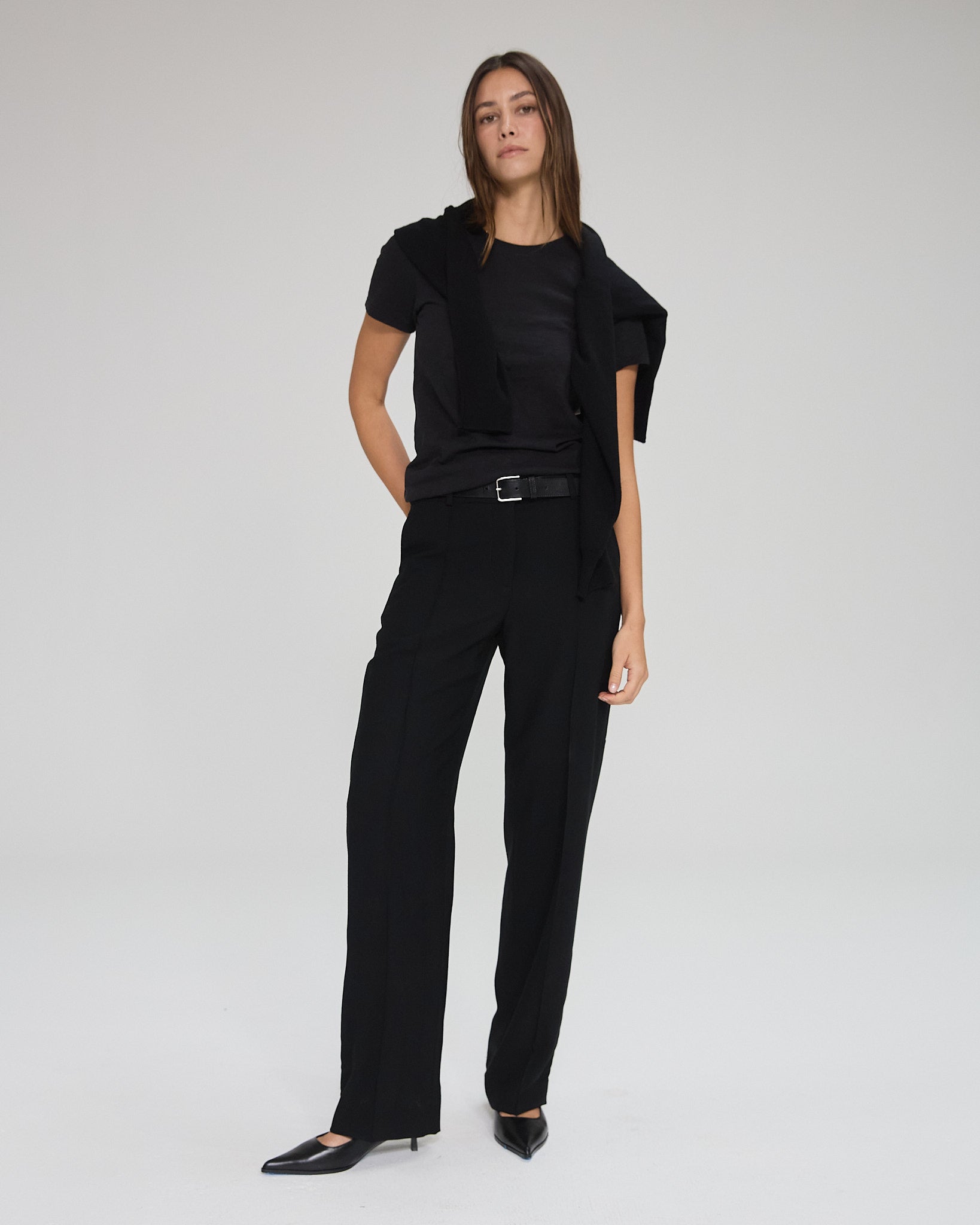 Model wearing black trousers in a white background. Made from sustainable deadstock materials.
