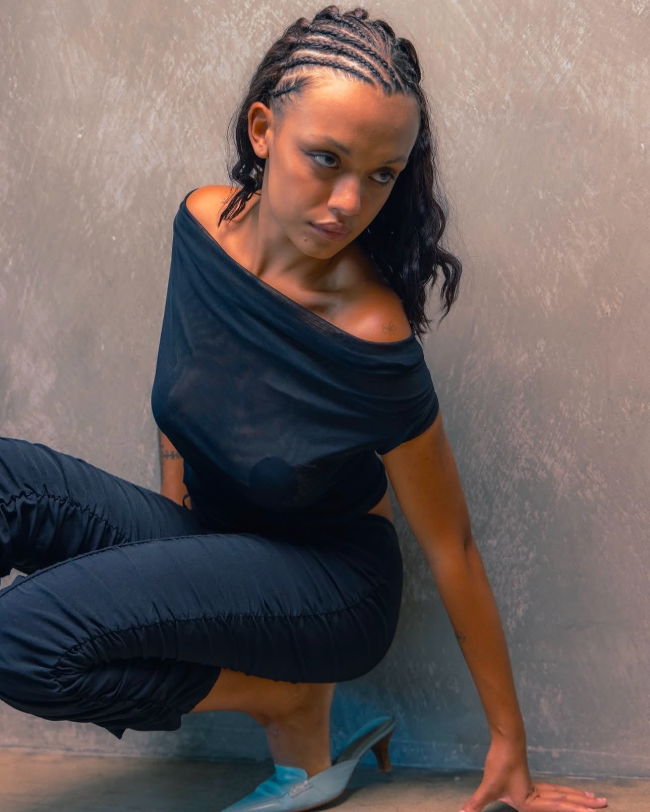 A model wearing the black city tank in an aesthetically background. 100% made from sustainable deadstock materials.